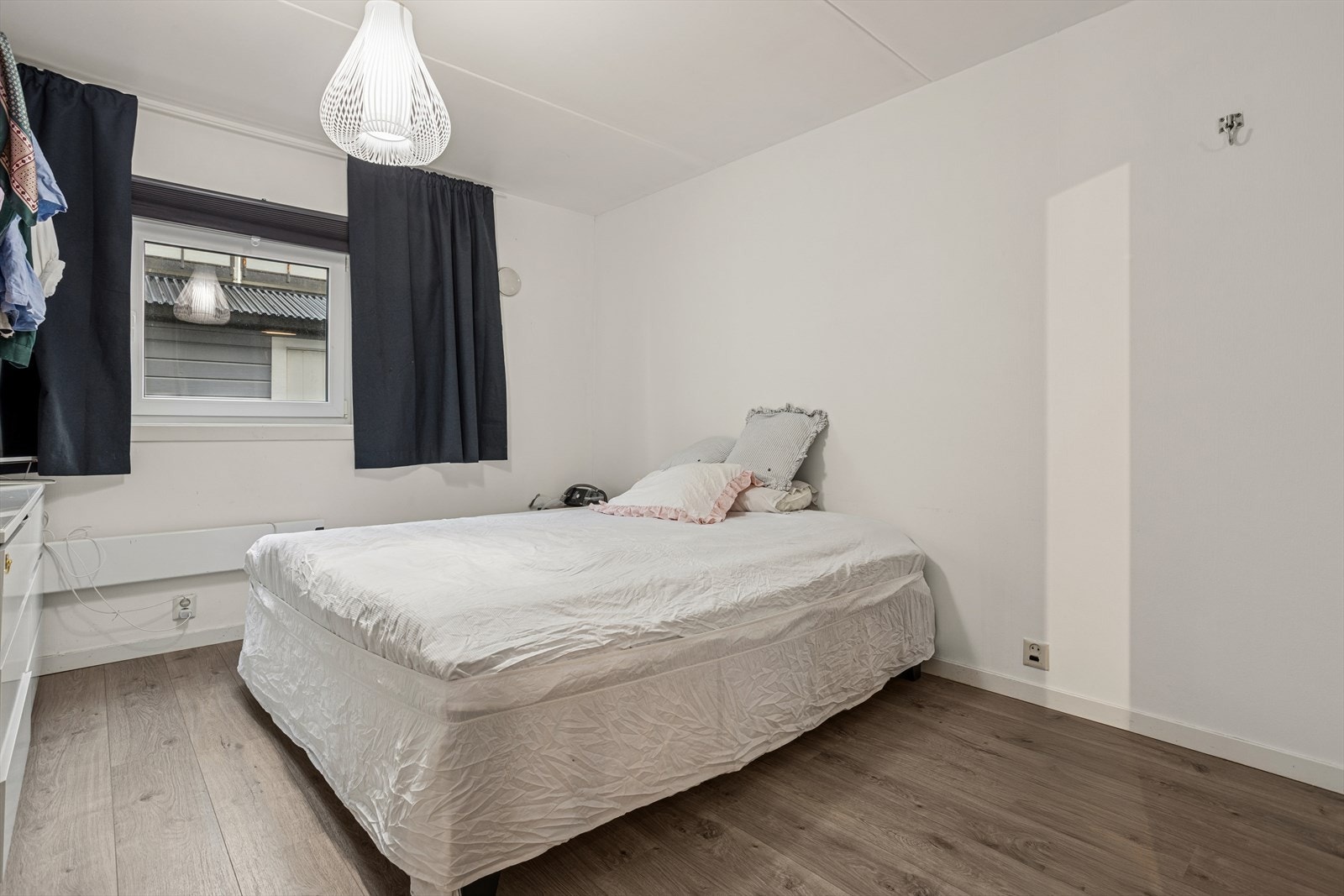 Hovedsoverommet med god plass til dobbeltseng og nattbord, og oppbevaringsplass i garderobeskap Galleribilde