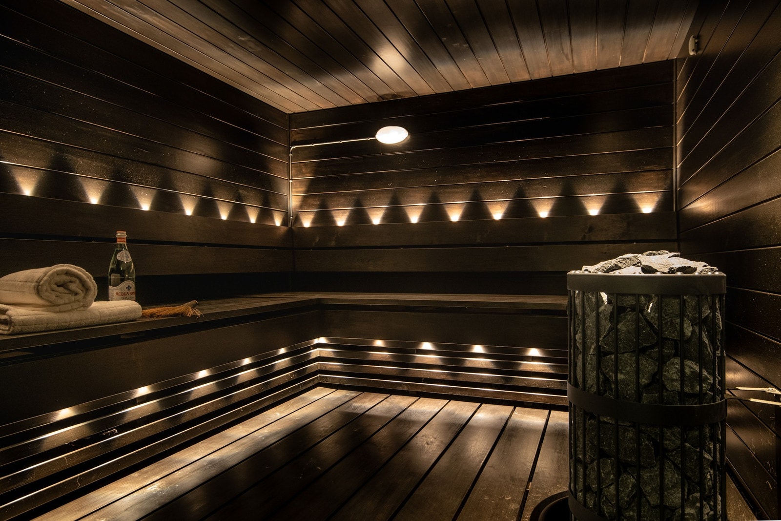 Badstue med flislagte overflater, trepanel og montert badstueovn - perfekt for avslapning og velvære. Galleribilde