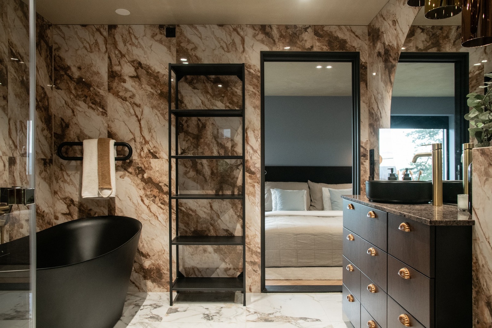 En elegant skyvedør gir direkte adkomst mellom badet og hovedsoverommet, og tilfører rommet en tydelig hotell- og spa-følelse. Galleribilde