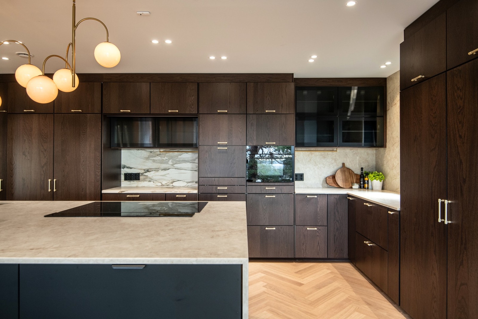 Veggen over benkeskapene er kledd med platekledning i samme uttrykk som benkeplaten, noe som gir et helhetlig og påkostet preg. Galleribilde