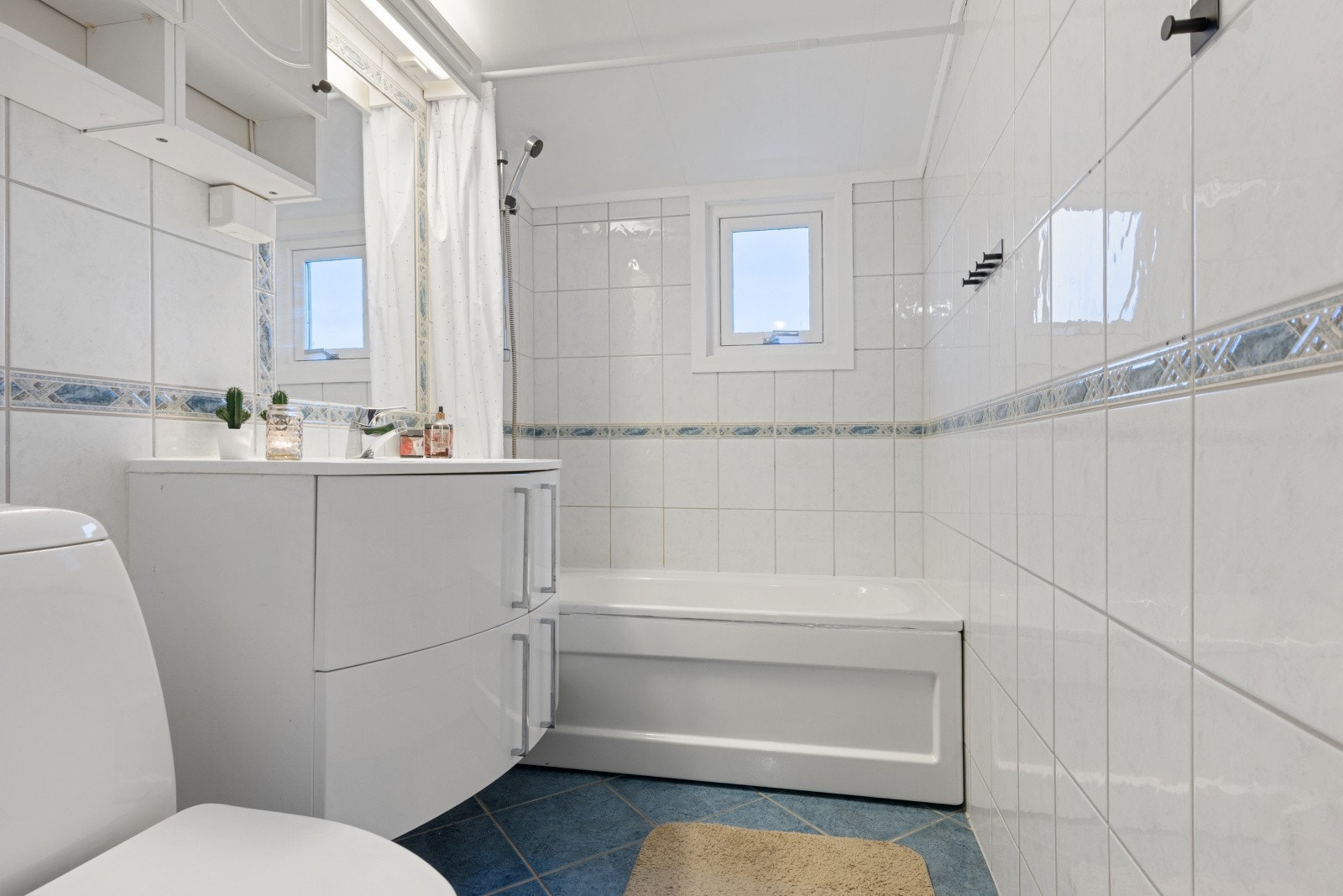 Her finner du badekar m/dusjgarnityr på vegg, toalett og baderomsinnredning Galleribilde