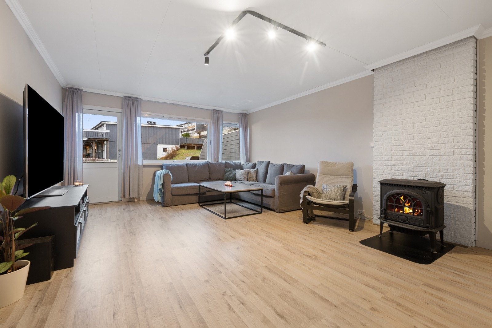 Det er store vindusflater som slipper inn rikelig med dagslys og vedovn som gir rask oppvarming på kjølige dager Galleribilde