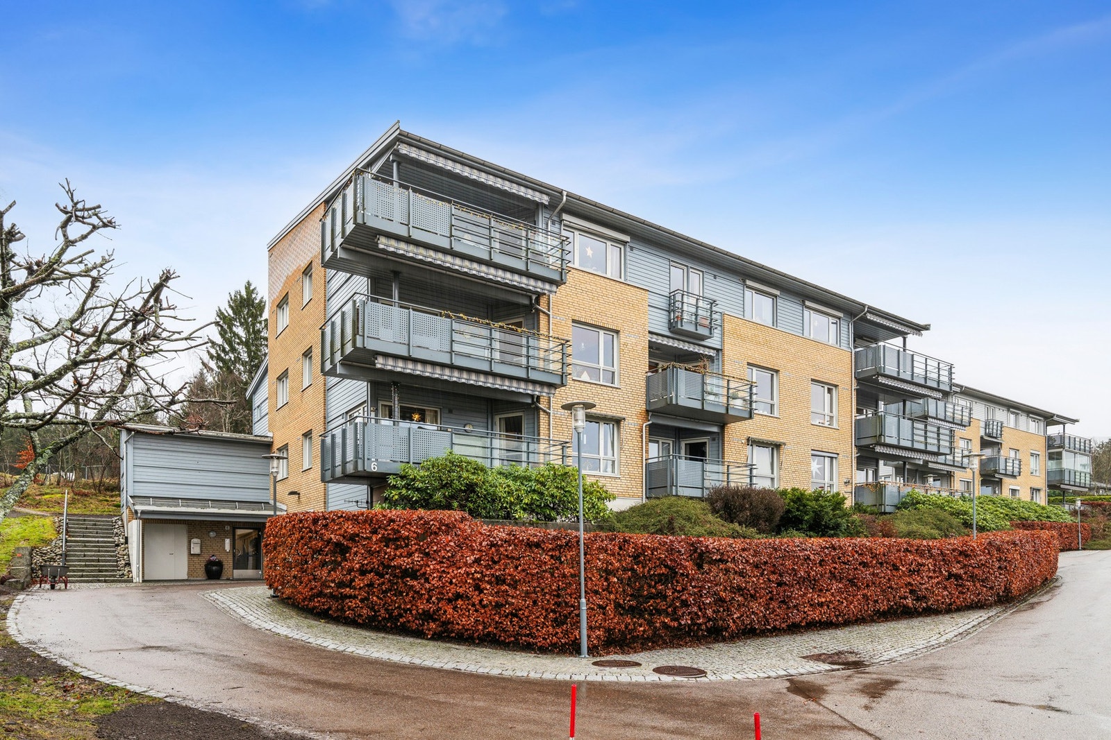 Moderne leilighetsbygg med balkonger, omgitt av velholdt uteområde og asfaltert innkjørsel. Galleribilde