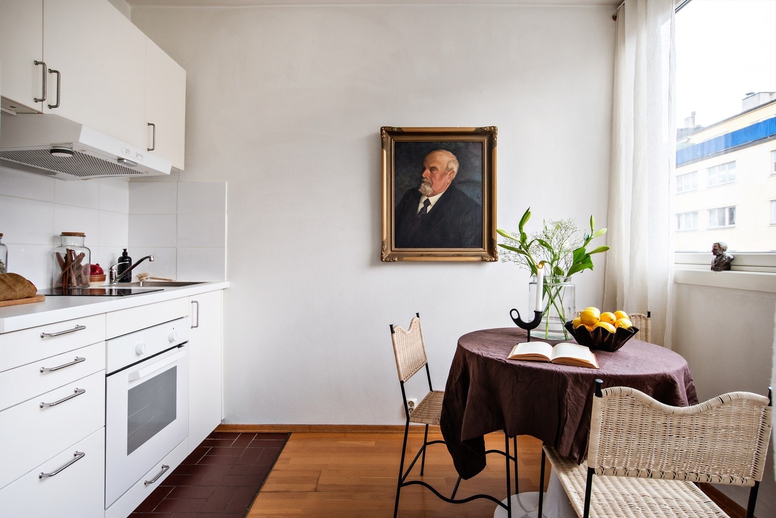 Kjøkkeninnredning med slette fronter og benkeplate med nedfelt koketopp og oppvaskkum av stål Galleribilde