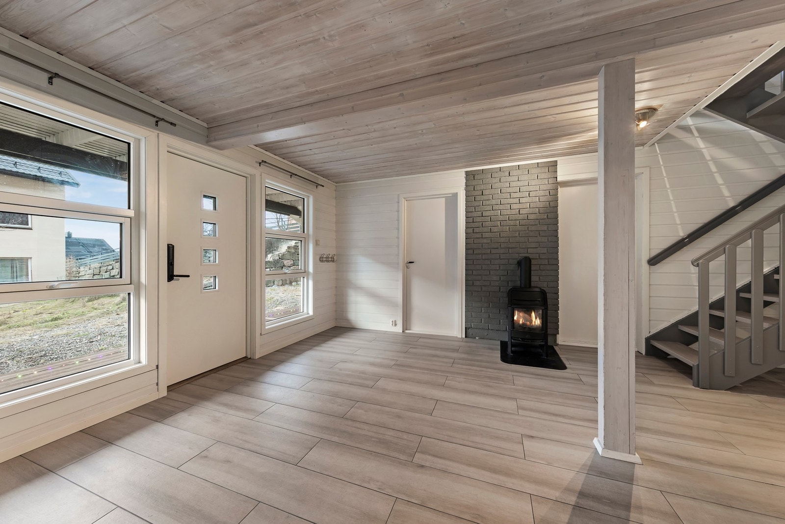 Romslig hall med varme i gulvet og vedovn Galleribilde