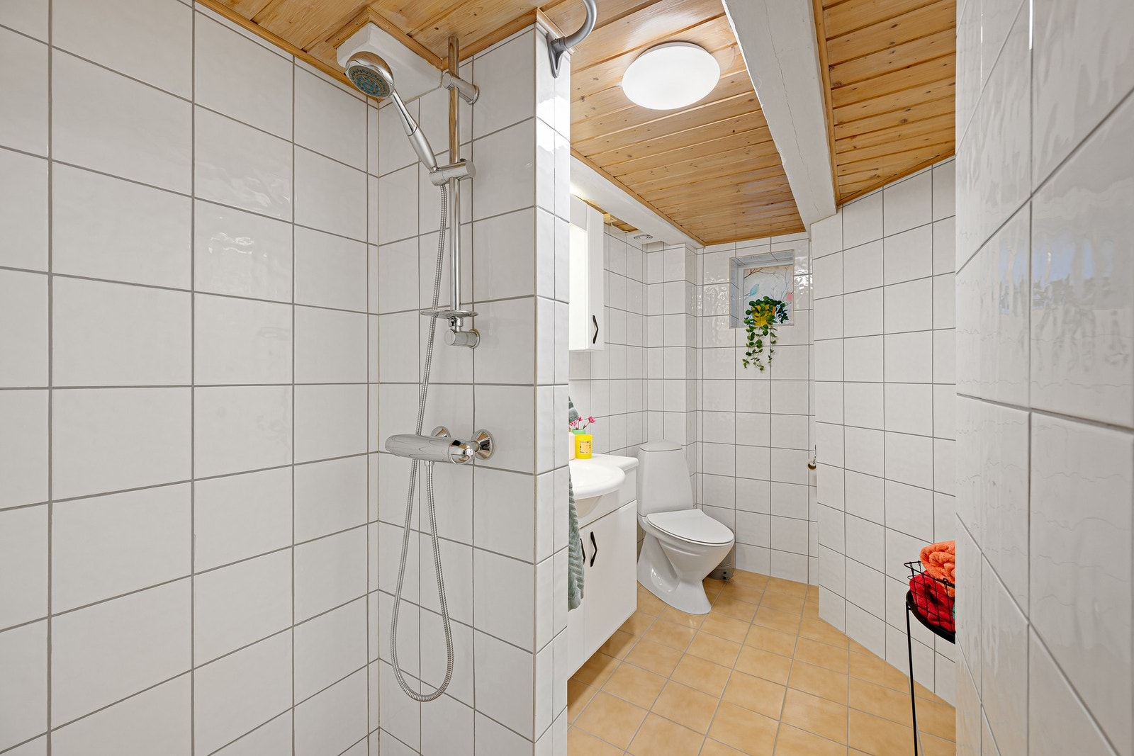 Lyst bad med flislagte overflater og romslig dusjsone. Galleribilde