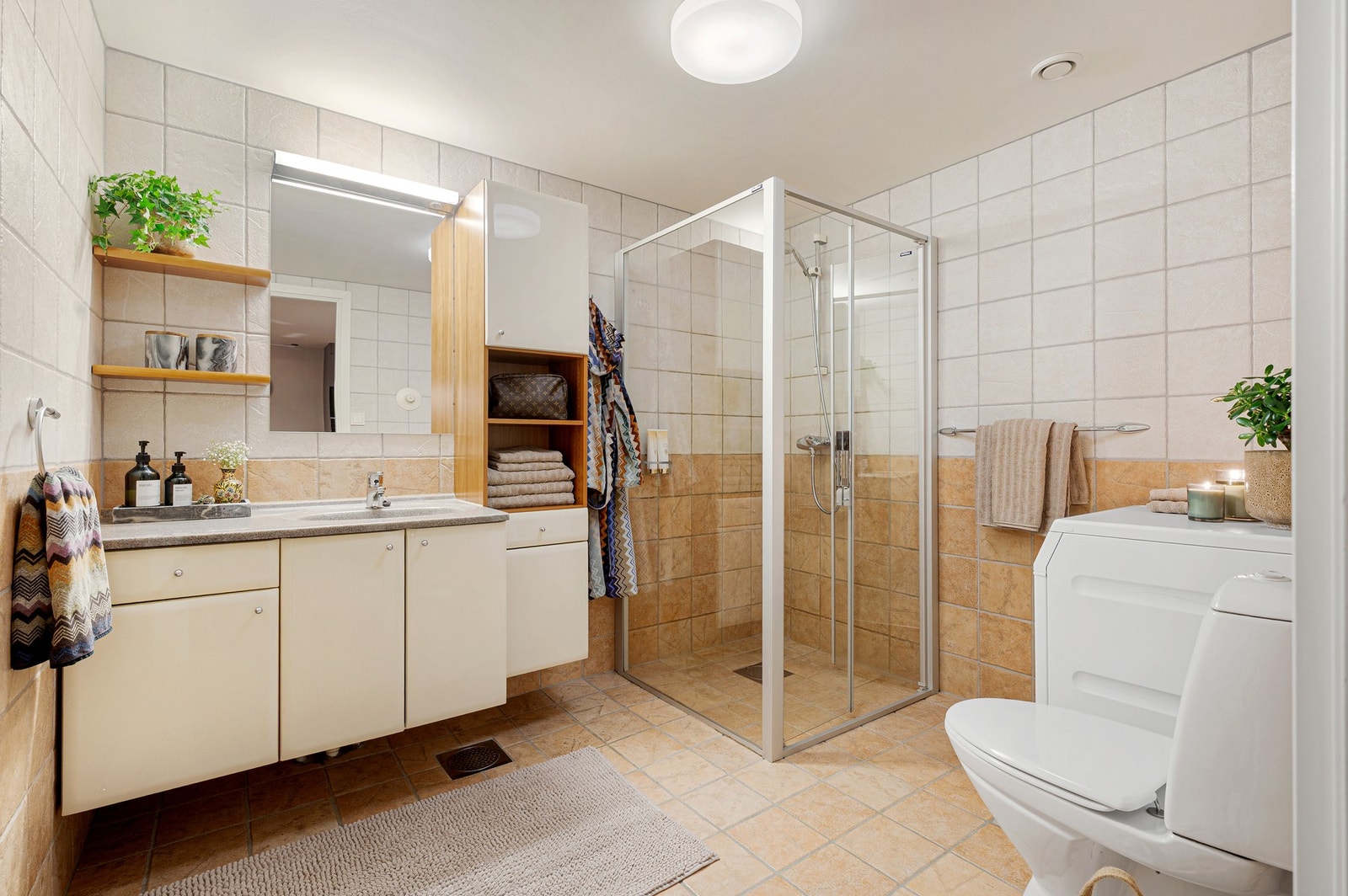 Bad med flislagte overflater og funksjonell planløsning. Galleribilde