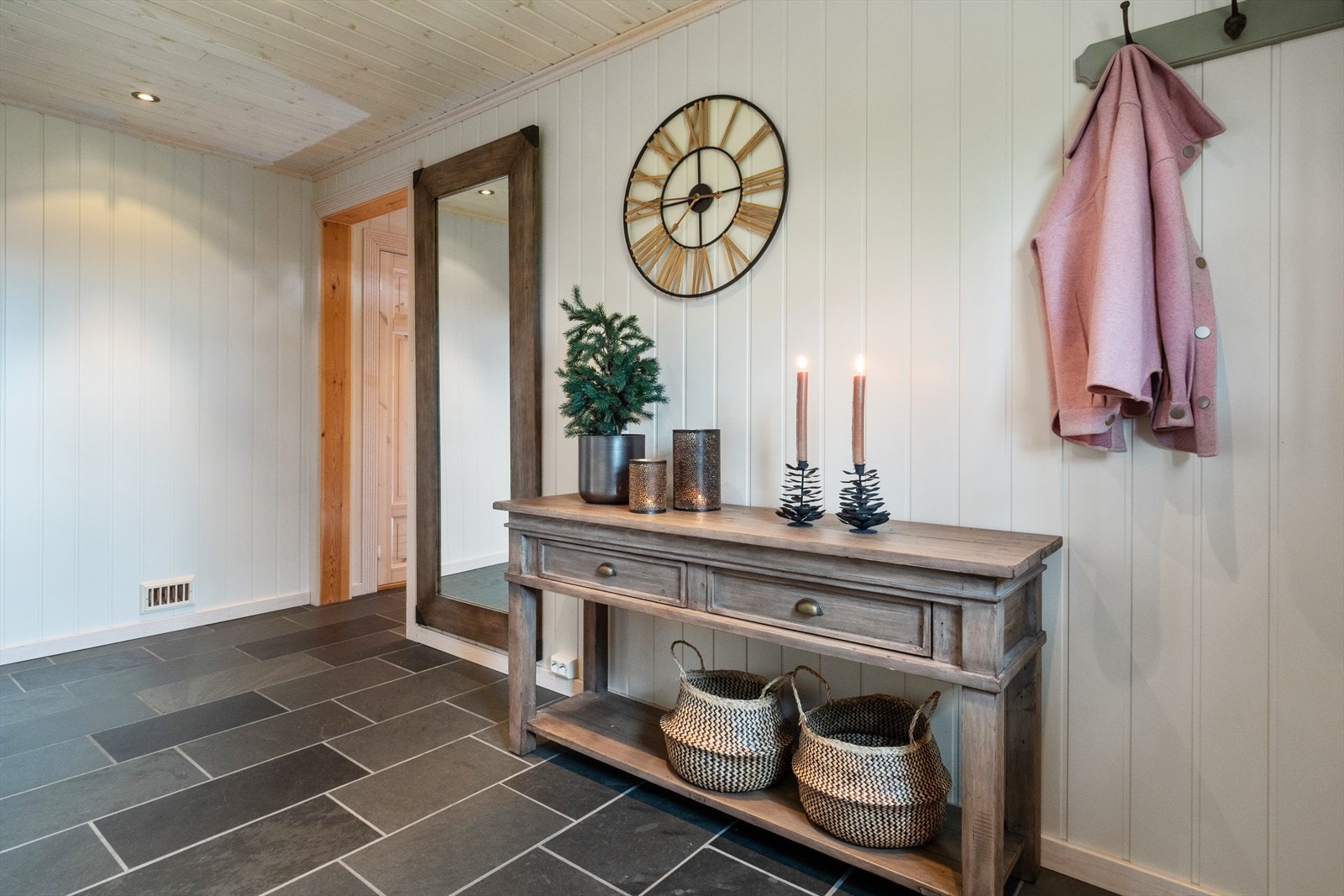 God og romslig hall med fliser på gulv, gulvvarme og lyse vegger. Her er det også et romslig garderobeskap med god plass for oppbevaring Galleribilde