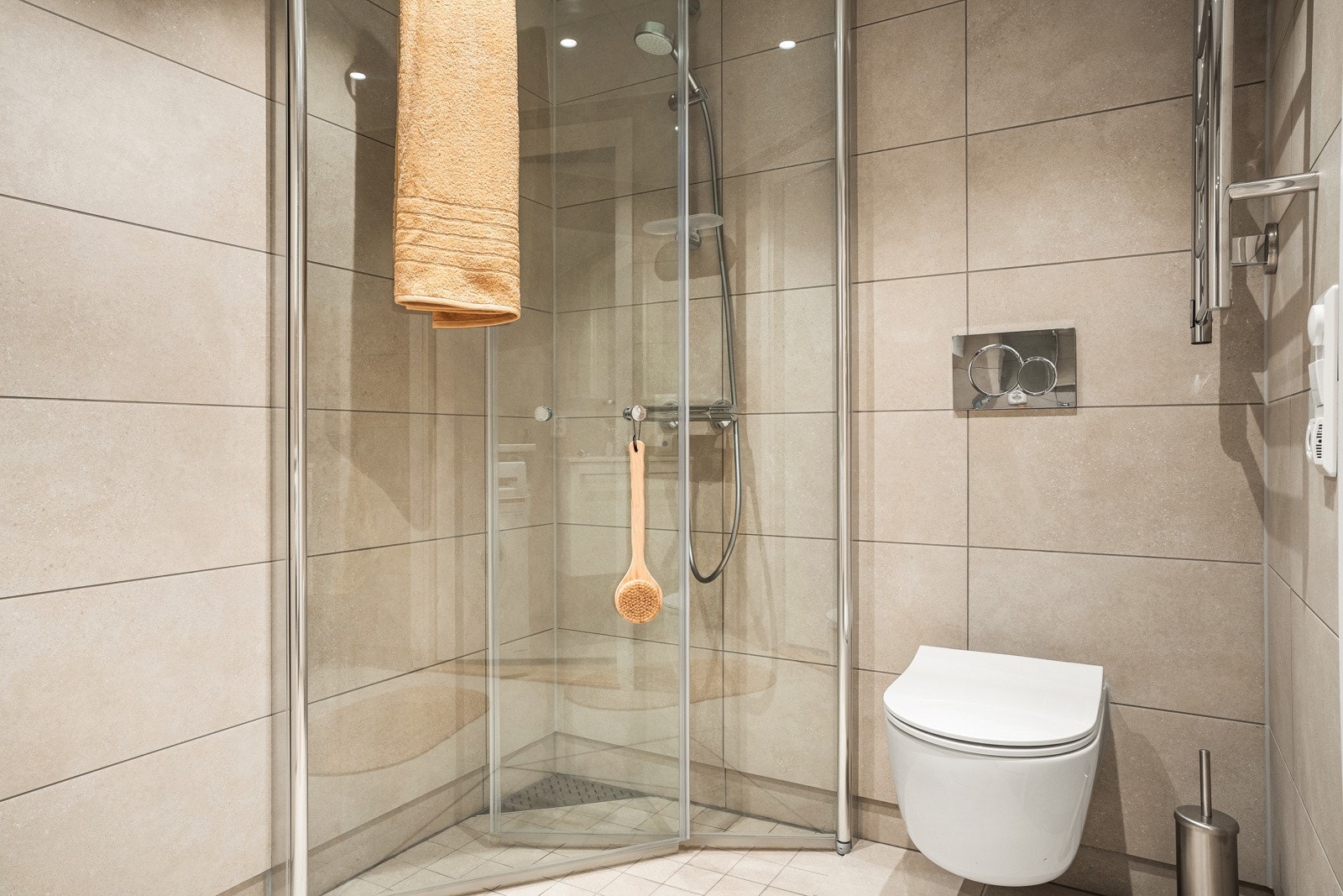 Nedfelt dusjsone gjør at vannet går naturlig i sluket. Det er lagt opp til vaskemaskin og tørketrommel på badet. Galleribilde