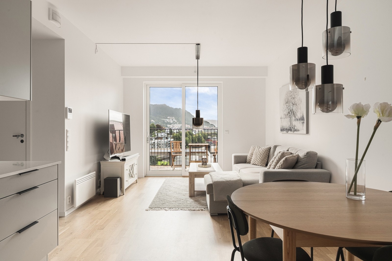 Videre kommer du inn i en lys og romslig stue med åpen løsning med kjøkken og utgang til balkong. Galleribilde