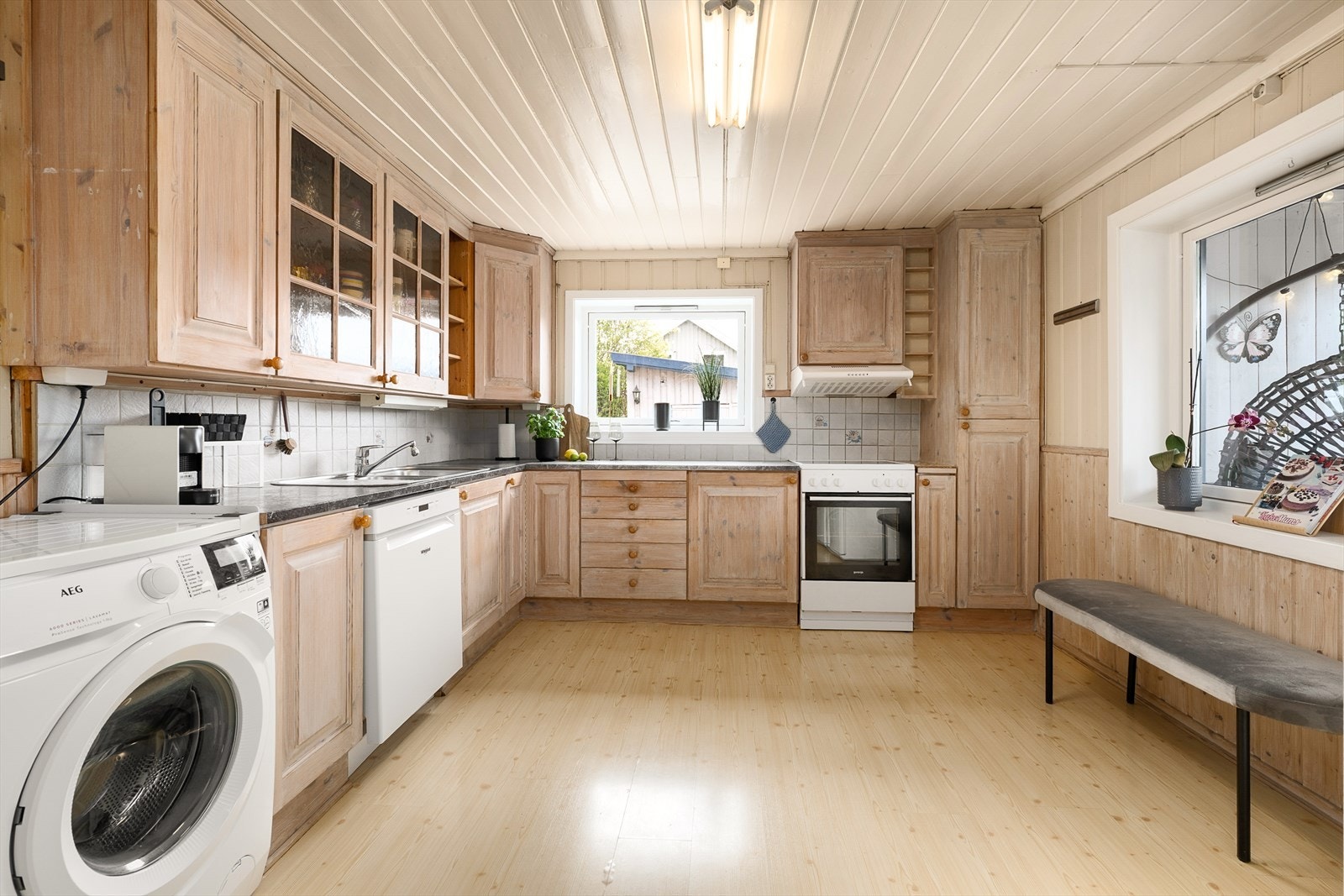 Kjøkkenet er stort og består av over-, underskap og arbeidsflater på benkeplate Galleribilde