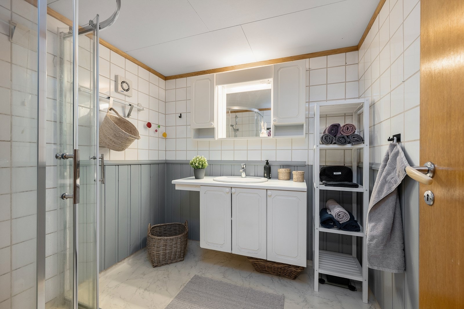 Lyst baderom med belegg, panel og fliser Galleribilde