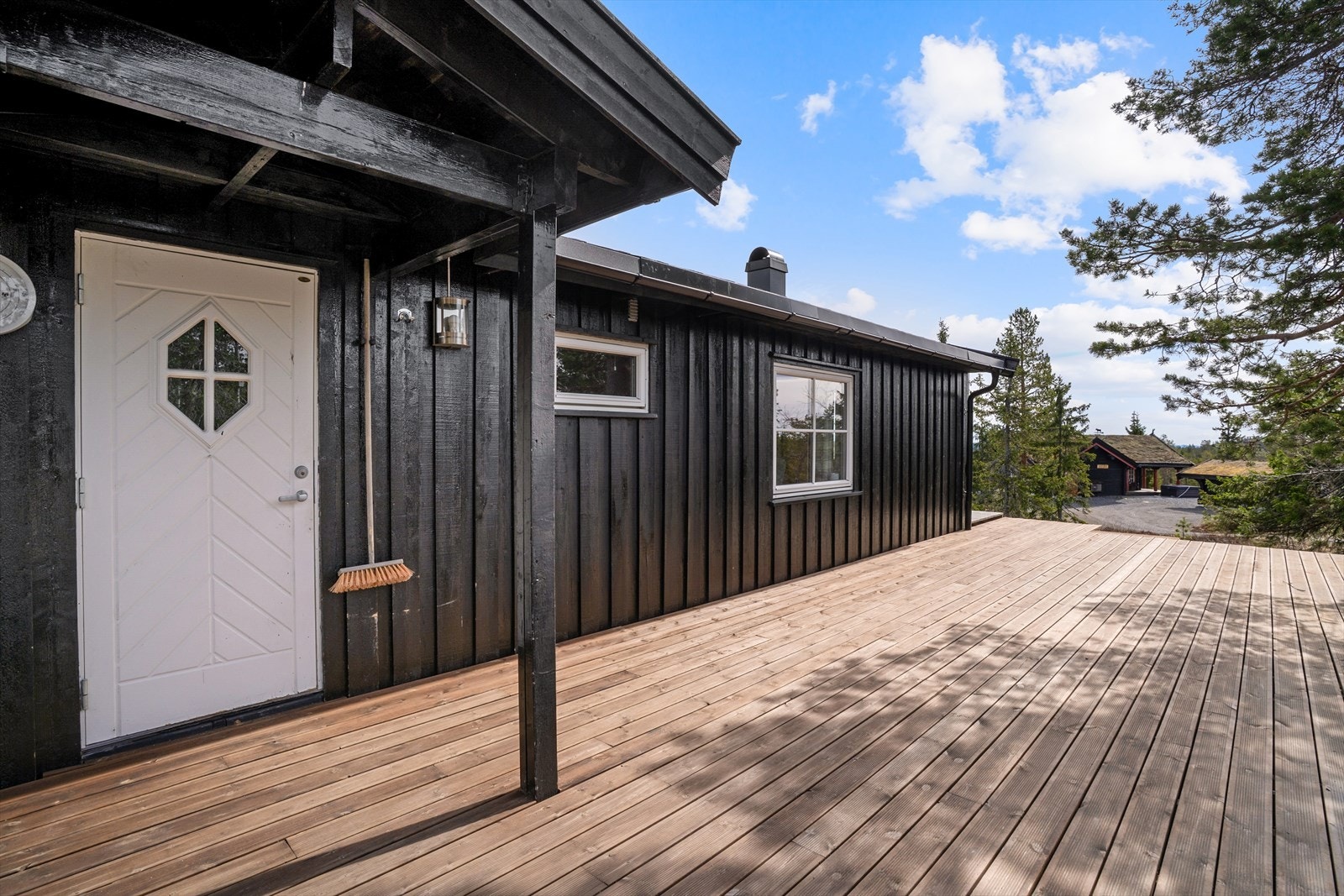 Inngangspartiet med takoverbygg, og en nyere etablert terrasseplatting. Galleribilde