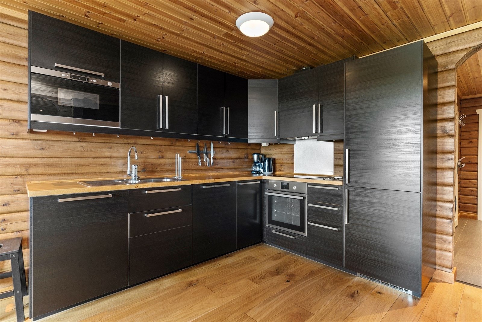 Kjøkkeninnredning med slette lakkerte fronter, med heltre benkeplate, oppvaskkum, ventilator med utluft og integrerte hvitevarer som stekeovn, platetopp, oppvaskmaskin, kjøl/frys. Galleribilde