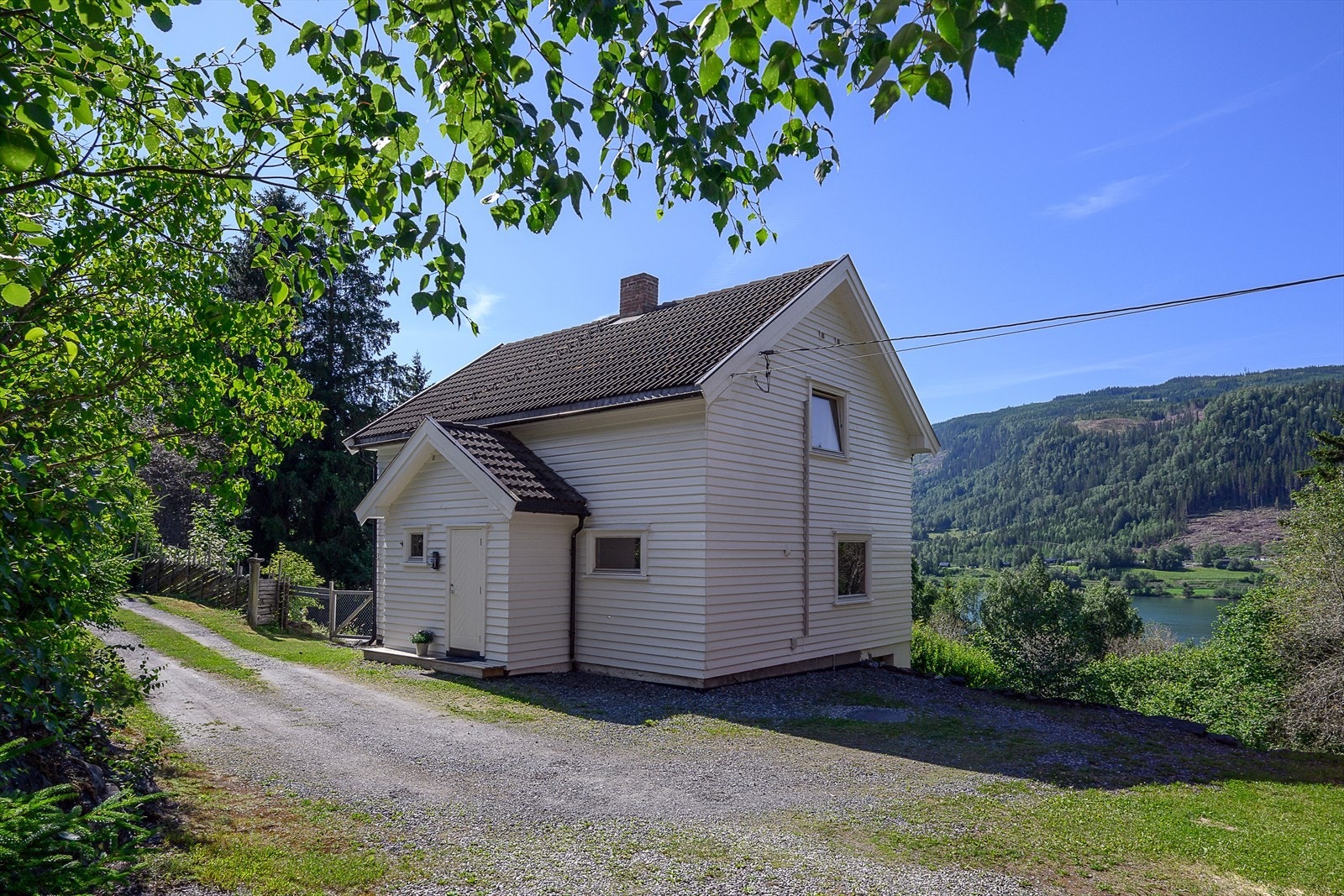Gårdsplassen er gruset og plass til parkering av biler Galleribilde
