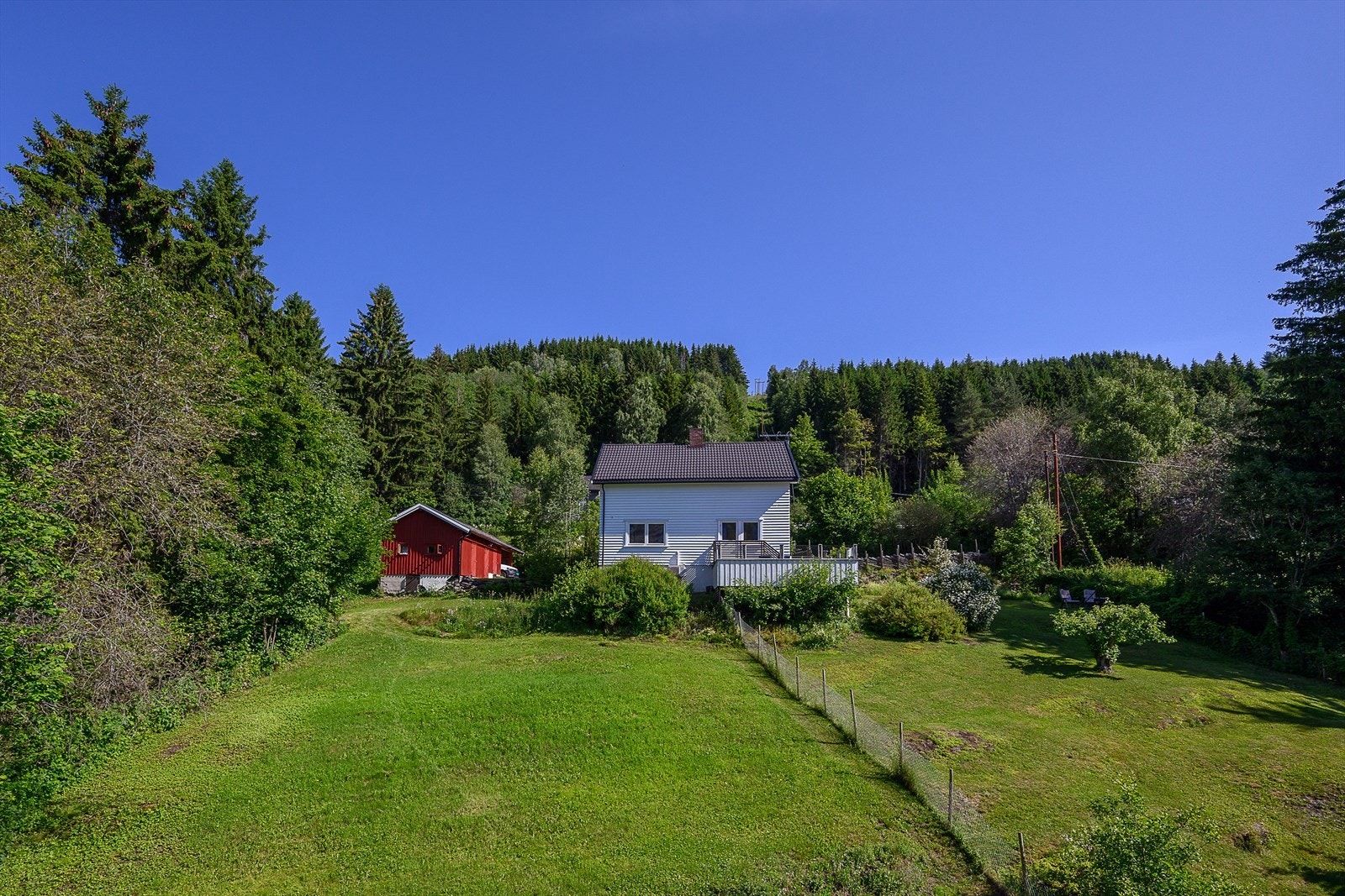 Tomten består av opparbeidet plenareal, enebolig og garasje/uthus Galleribilde