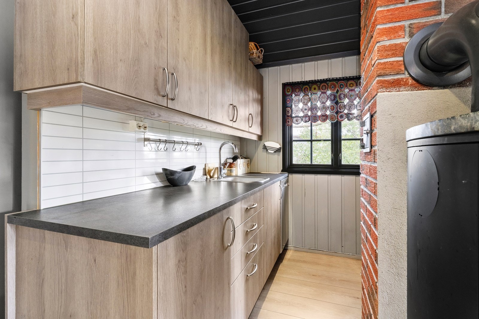 Et koselig kjøkken med innredning av glatte fronter. Godt utstyrt med hvitevarer, både med oppvaskmaskin, platetopp og ventilator. Galleribilde