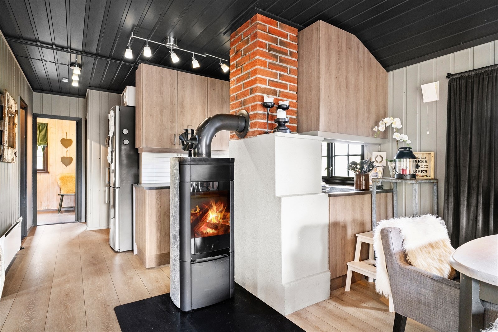 Det er halvåpen løsning mot kjøkken fra stuen. Nyere ildsted med kleberstein er montert i stua. Galleribilde