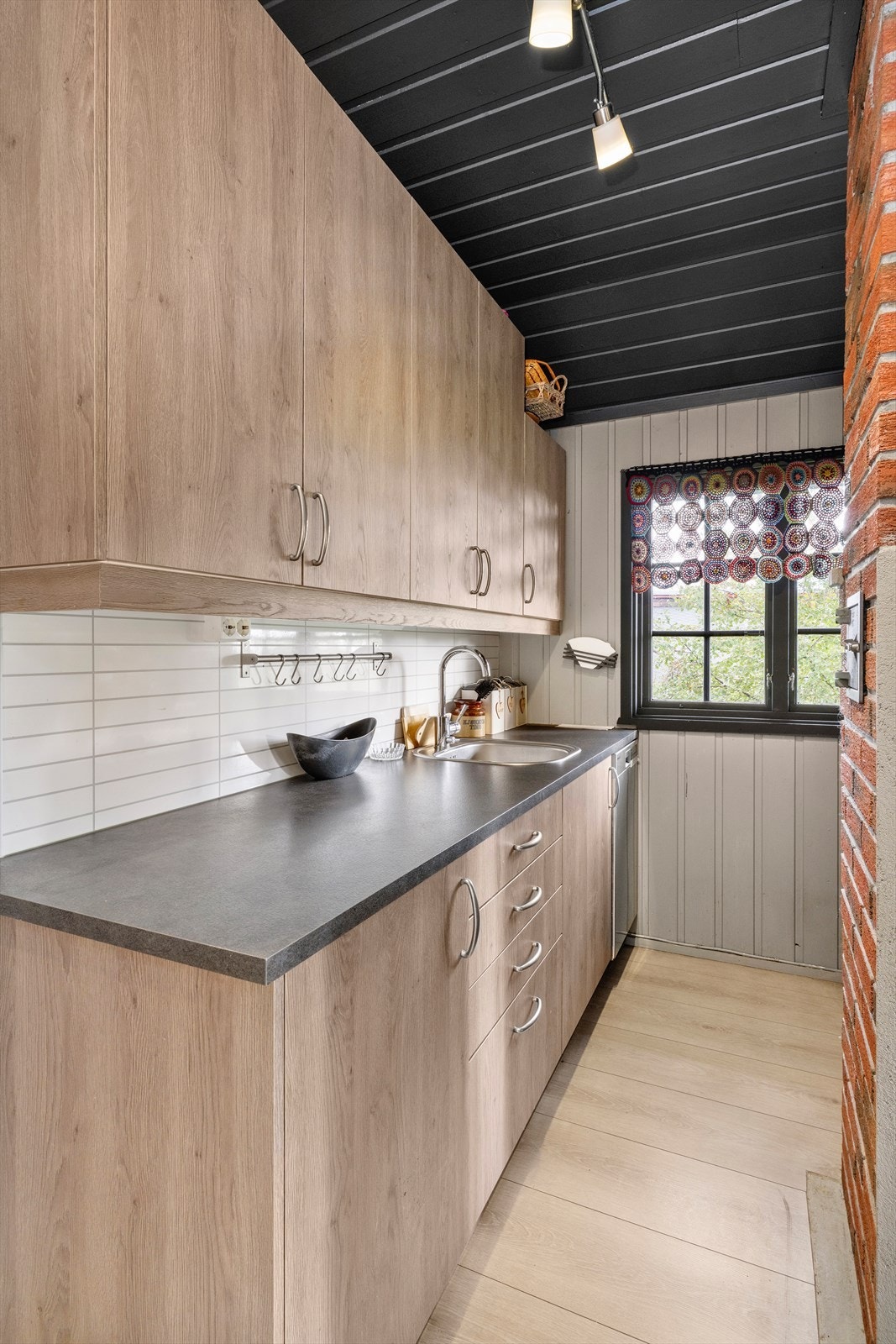 Benkeplaten er av laminat. Kjøkkenet har oppvaskmaskin, induksjonstopp, stekeovn og komfyrvakt. Bakvegg av kitchenboard plate. Lekker laminatvariant på gulvet som står seg godt til fargene i innredningen. Galleribilde