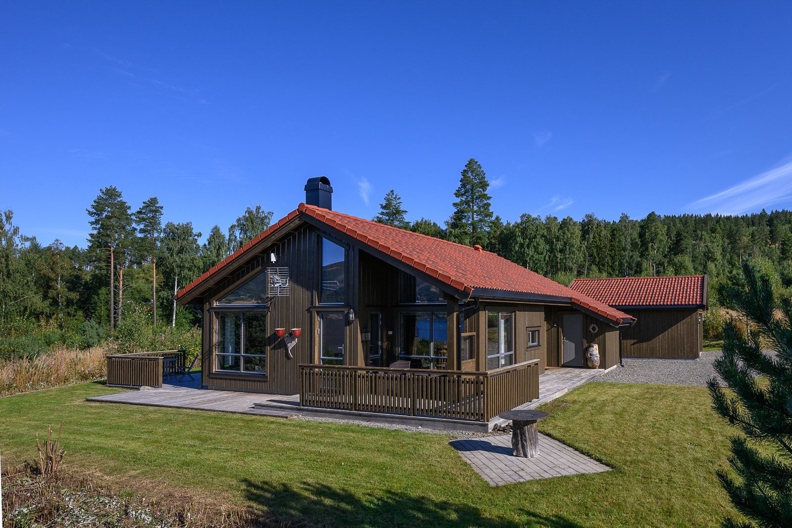 Eiendommen har et pent opparbeidet uteområde med plenareal og platting Galleribilde