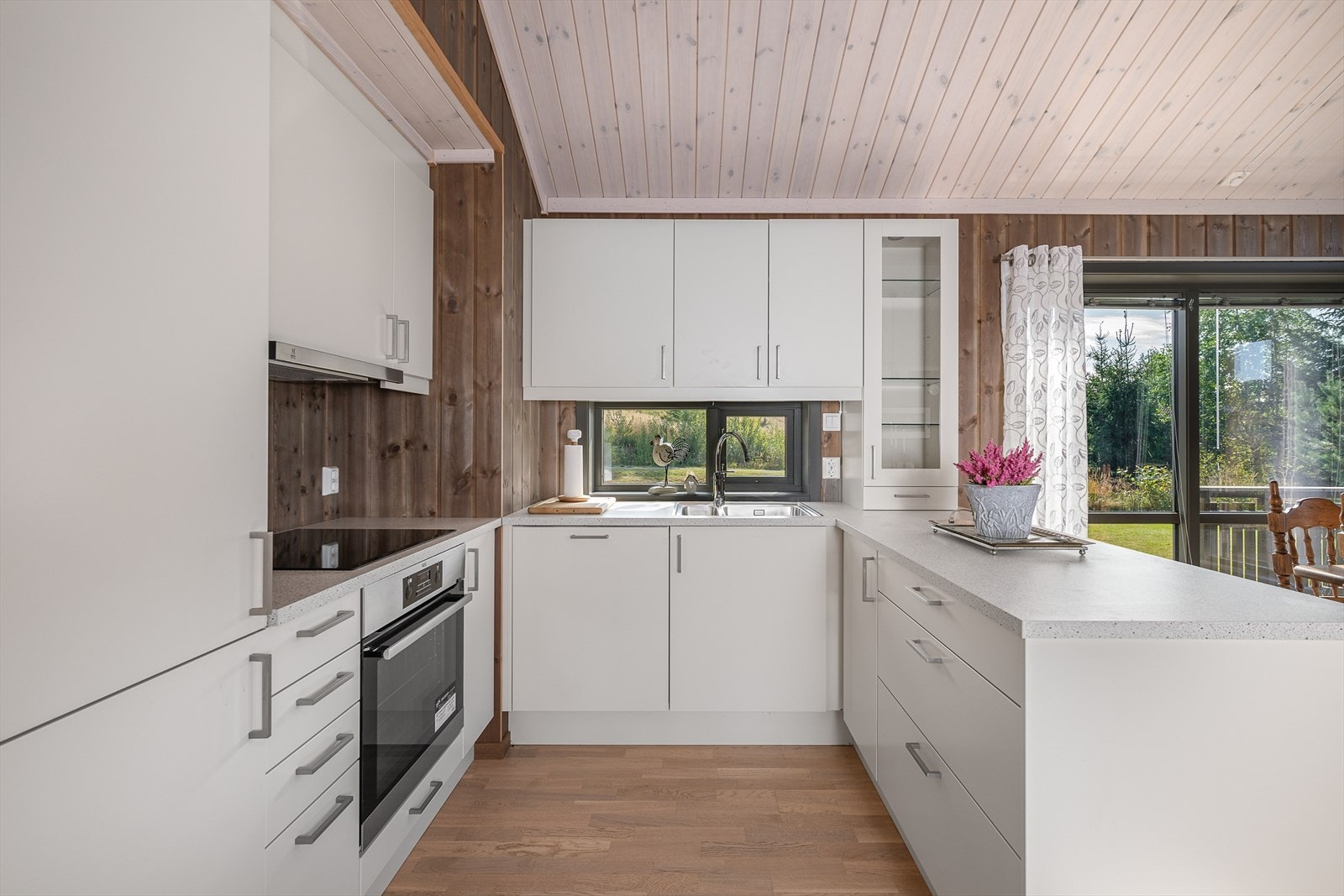 Innredningen har integrerte hvitevarer som komfyr, oppvaskmaskin, platetopp og kjøl-/fryseskap Galleribilde