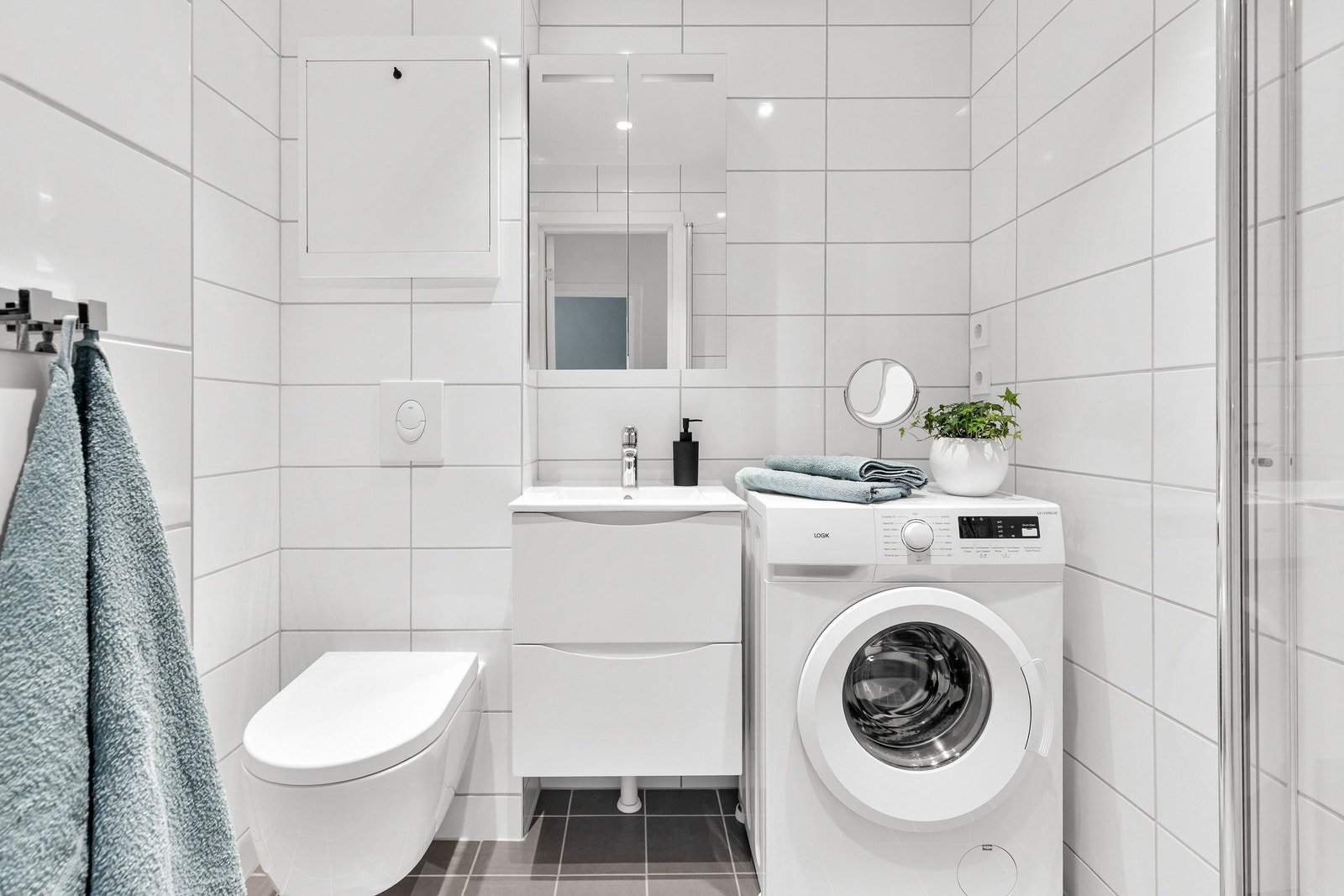 Nyoppusset bad med vegghengt toalett, servant og opplegg for vaskemaskin Galleribilde