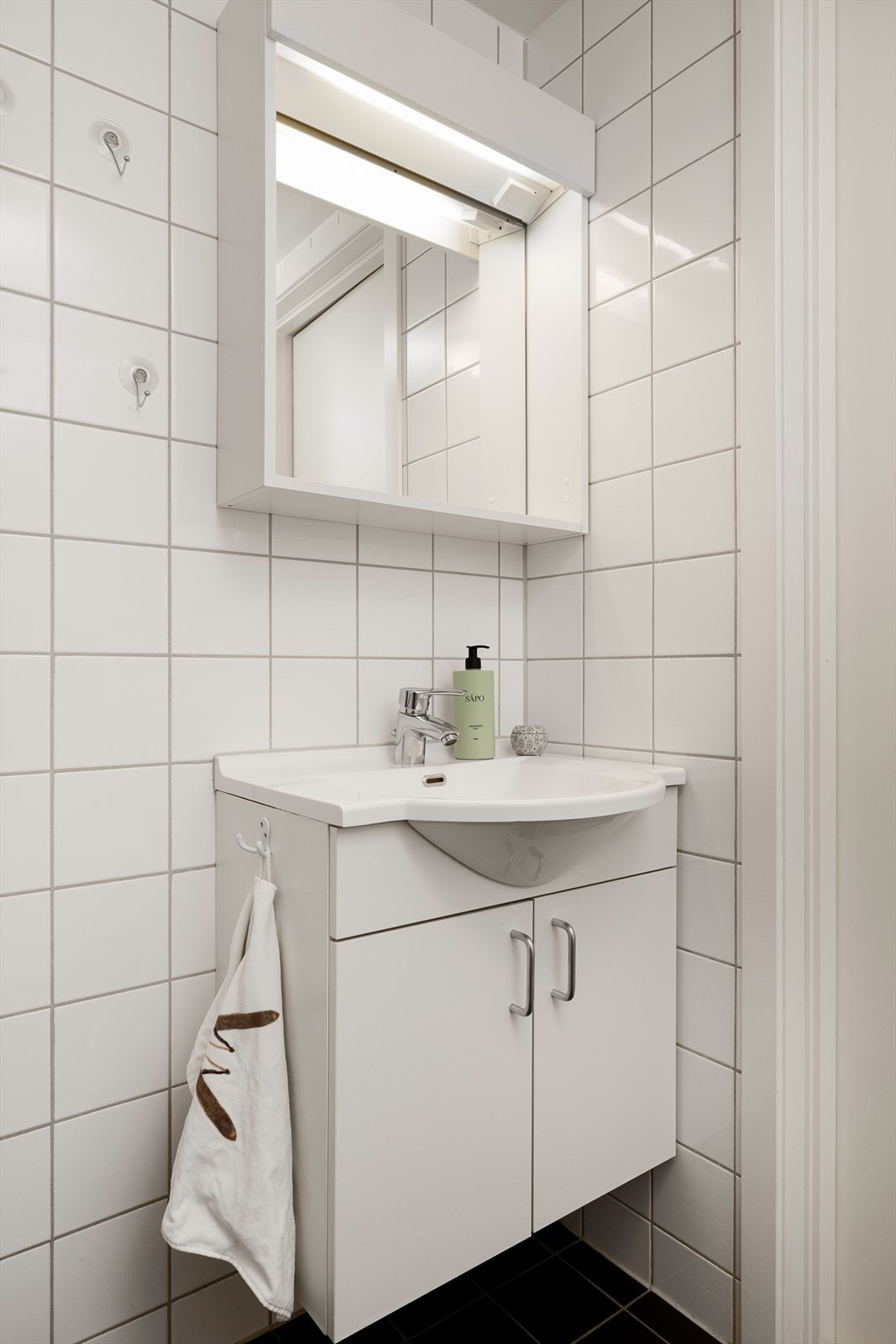 Baderomsinnredning med servant og speilskap med belysning. Galleribilde