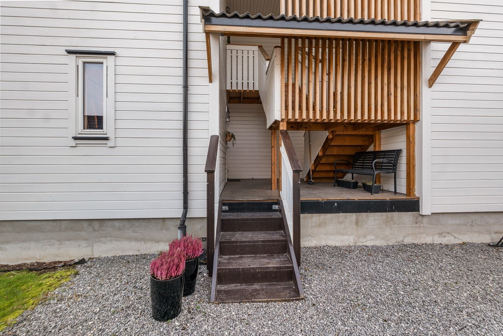 Trapp med rekkverk leder til inngangsparti, delvis overbygget. Galleribilde