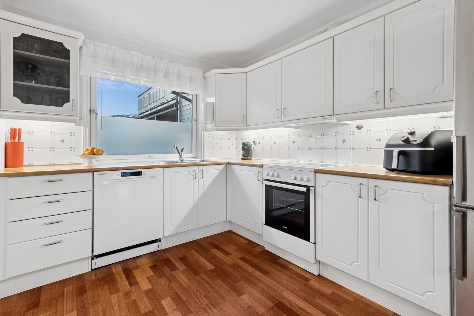 Det er frittstående hvitevarer og kjøkkenventilator med avtrekk ut. Galleribilde