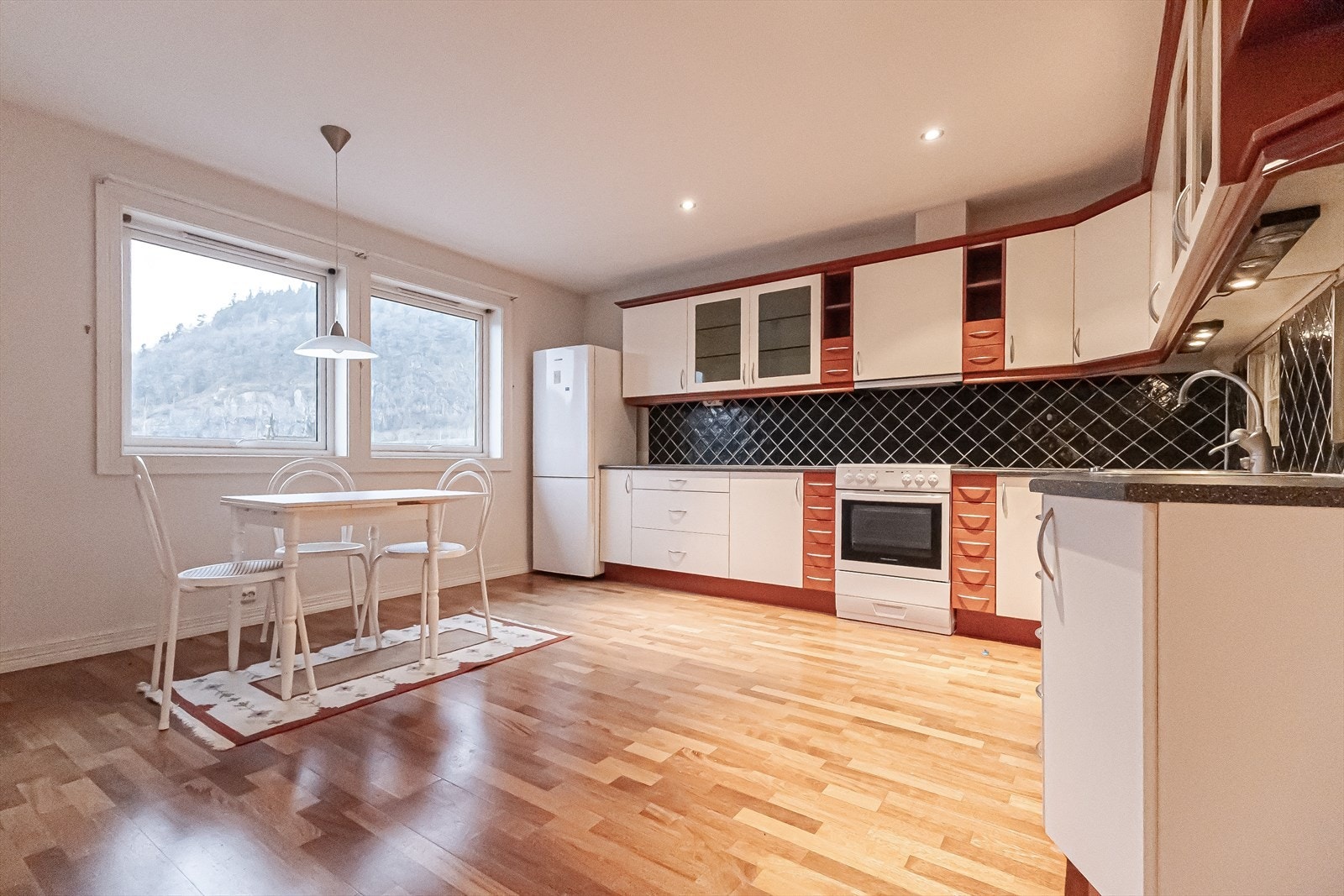 Kjøkkenet har rikelig med skap og benkeplass Galleribilde