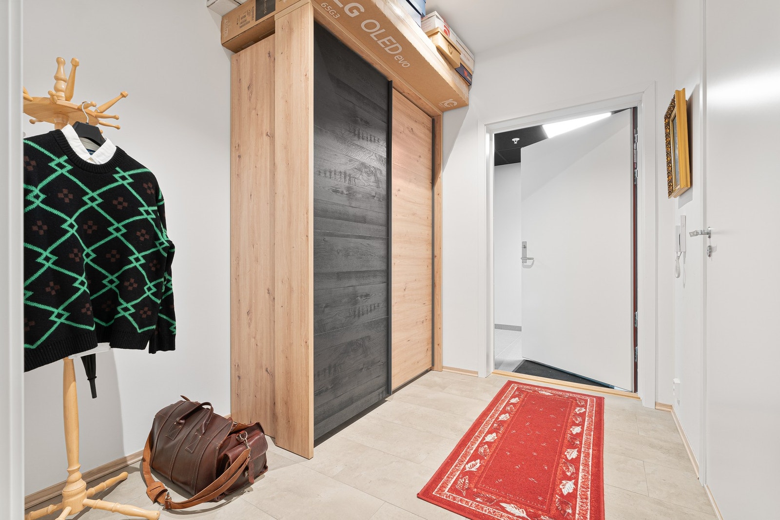 Innbydende entré med flislagt gulv og praktisk gulvvarme. Garderobeløsningen medfølger i handelen. Galleribilde