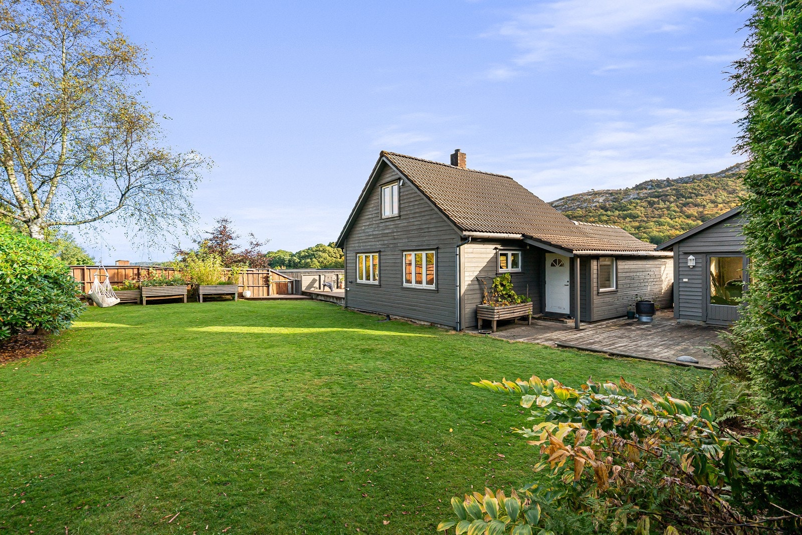 Flotte, opparbeidede uteområder med frodige planter, solrik terrasse og velstelt plen - perfekt for avslapning og hageglede. Galleribilde
