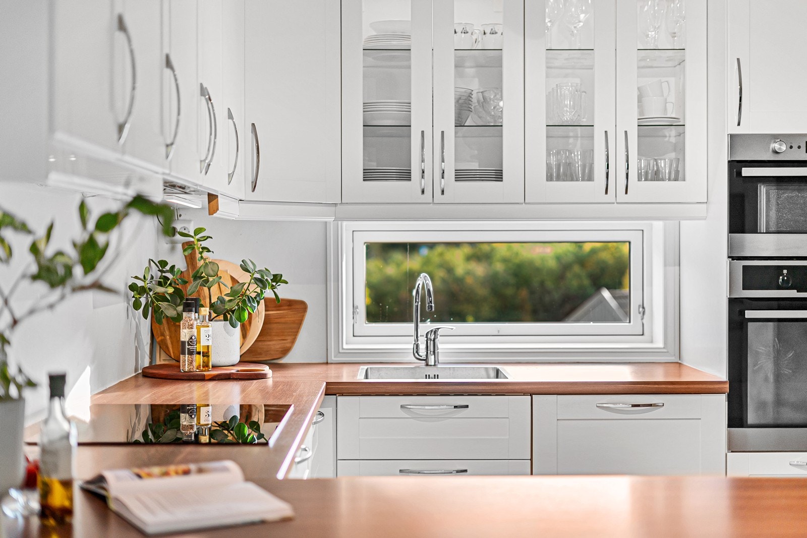 Lys, praktisk og innbydende kjøkkenløsning. Galleribilde