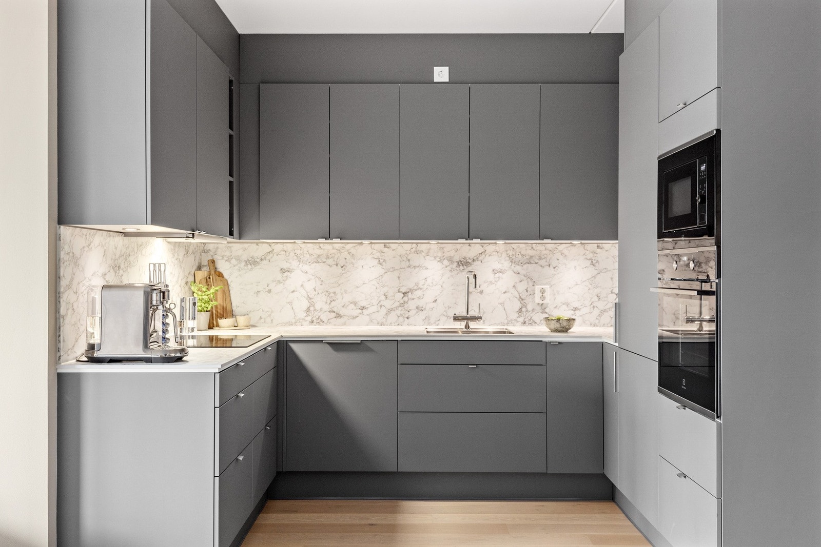 Kjøkkenet har innredning av slette fronter og benkeplate av kompositt. Kjøkkenet er fra 2023 og komplett med integrerte hvitevarer Galleribilde