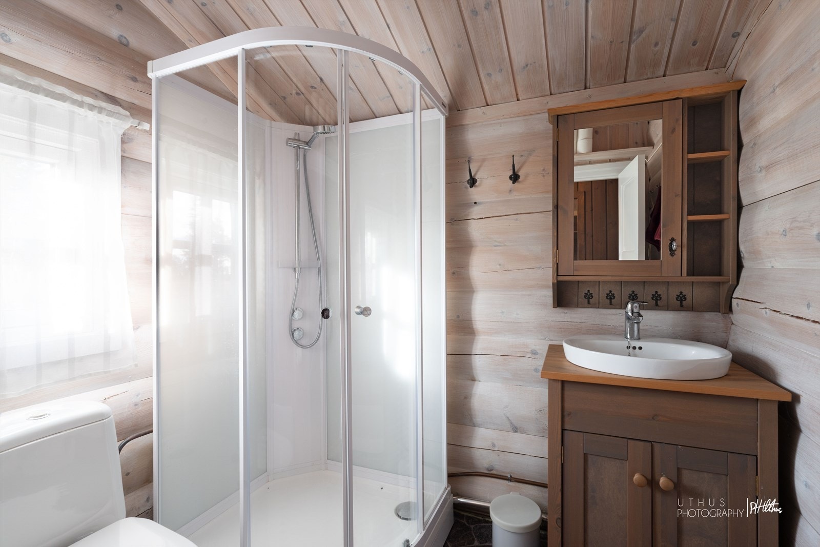 Badet har panelkledde vegger og er utstyrt med servant, toalett og dusjkabinett. Galleribilde