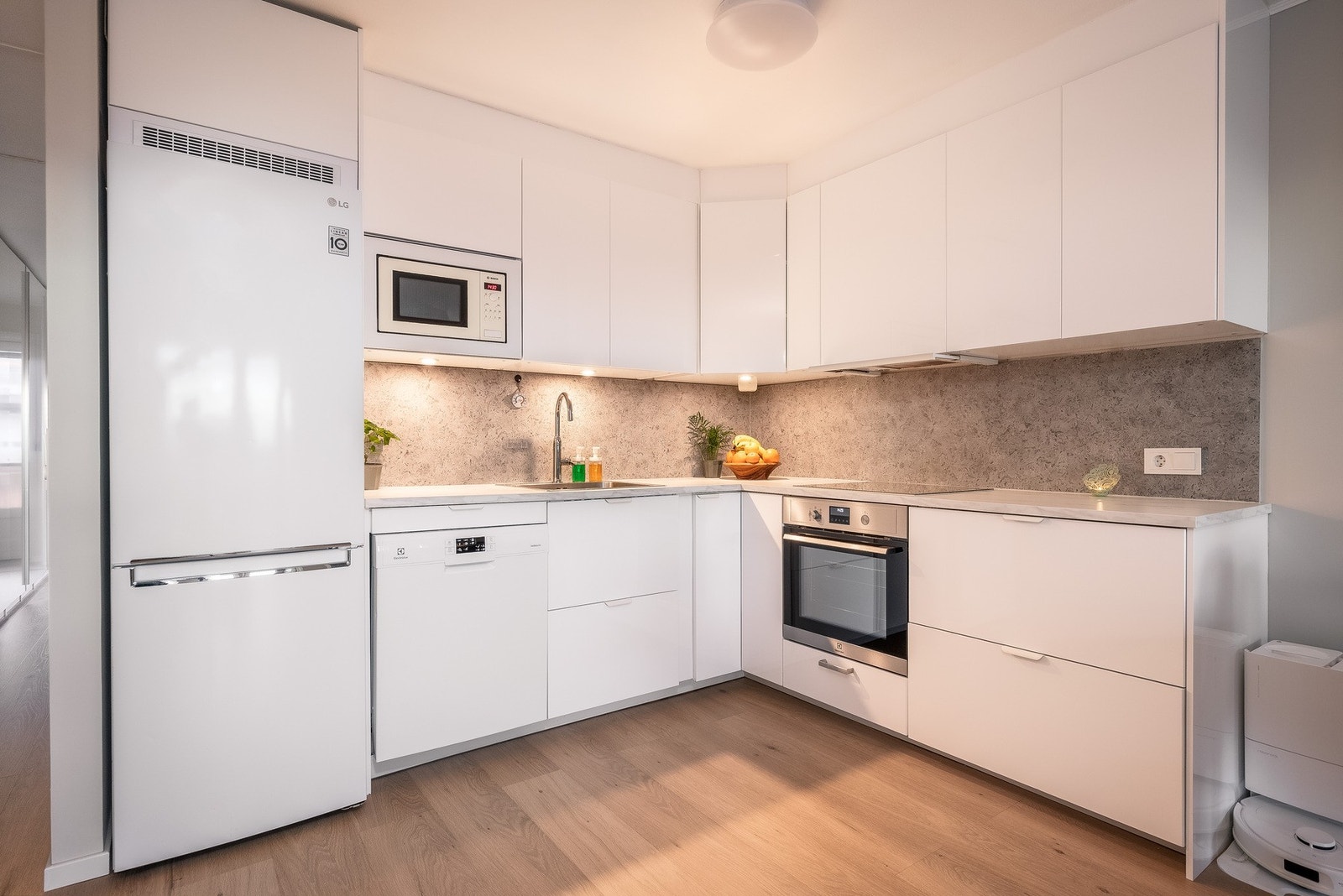 Integrerte hvitevarer inkluderer platetopp, stekeovn, mikroovn og oppvaskmaskin, samt frittstående kjøle-/fryseskap. Galleribilde