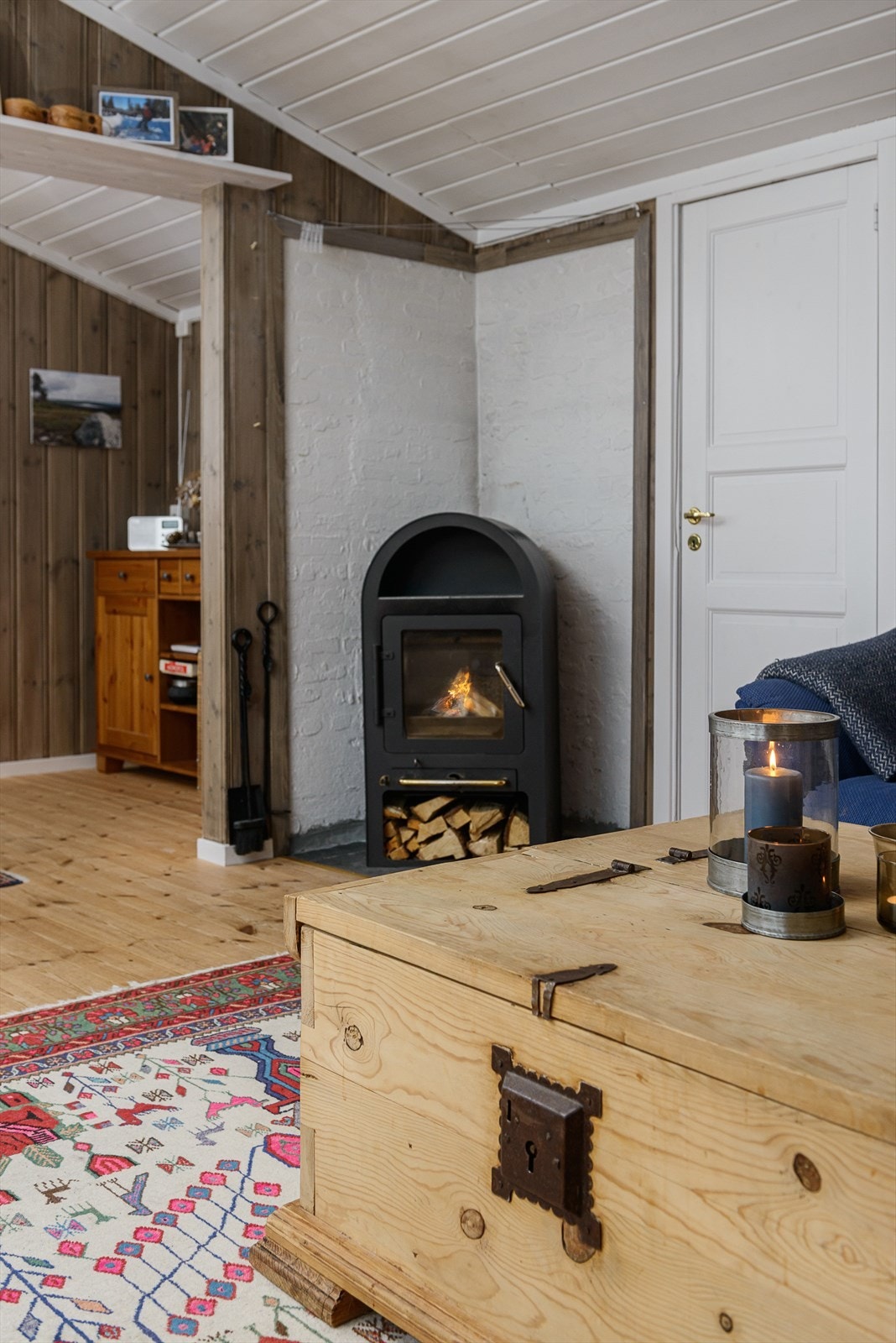 Fin peisovn er strategisk plassert midt i rommet, og gir godt med varme på de kjøligere dager. Galleribilde