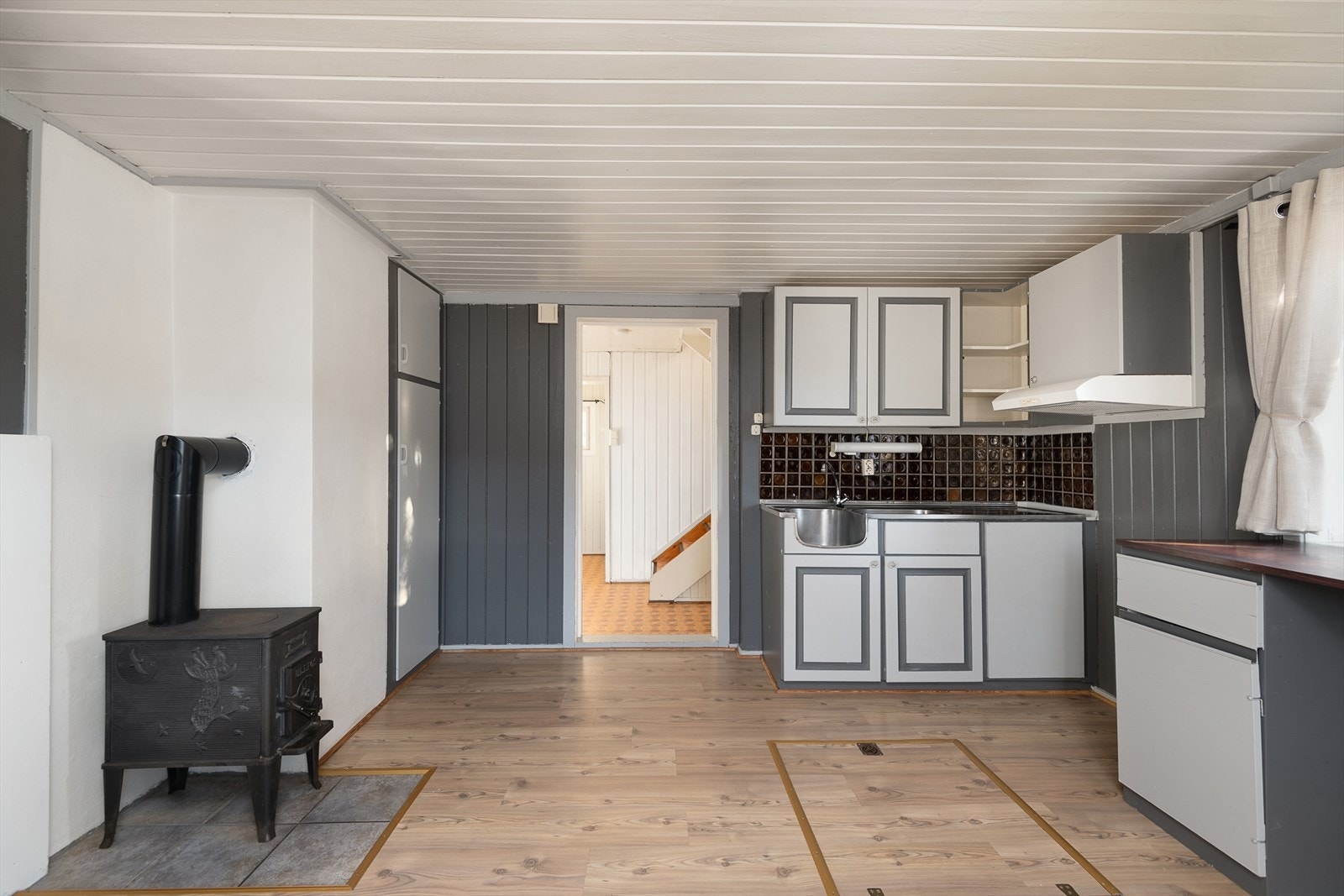 Eldre innredning bestående av underskap og veggskap med malte fronter. Galleribilde