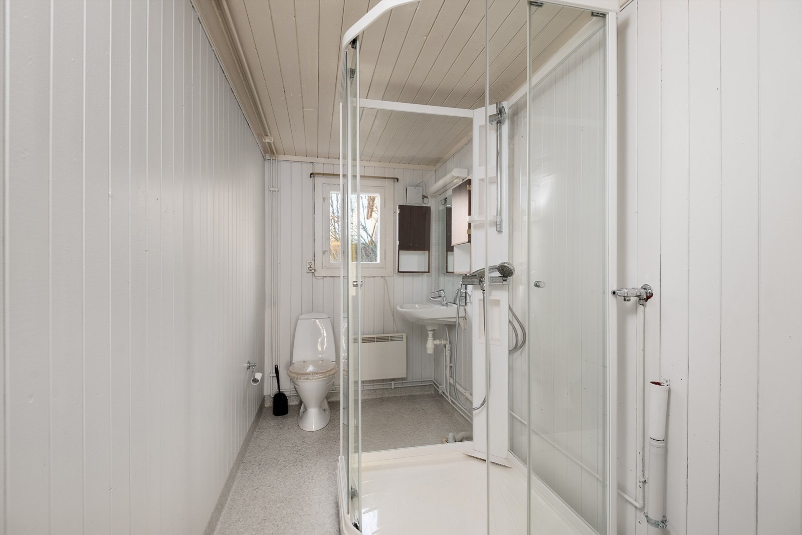 Baderommet er enkelt innredet med servant, wc og dusjkabinett samt opplegg for vaskemaskin. Galleribilde