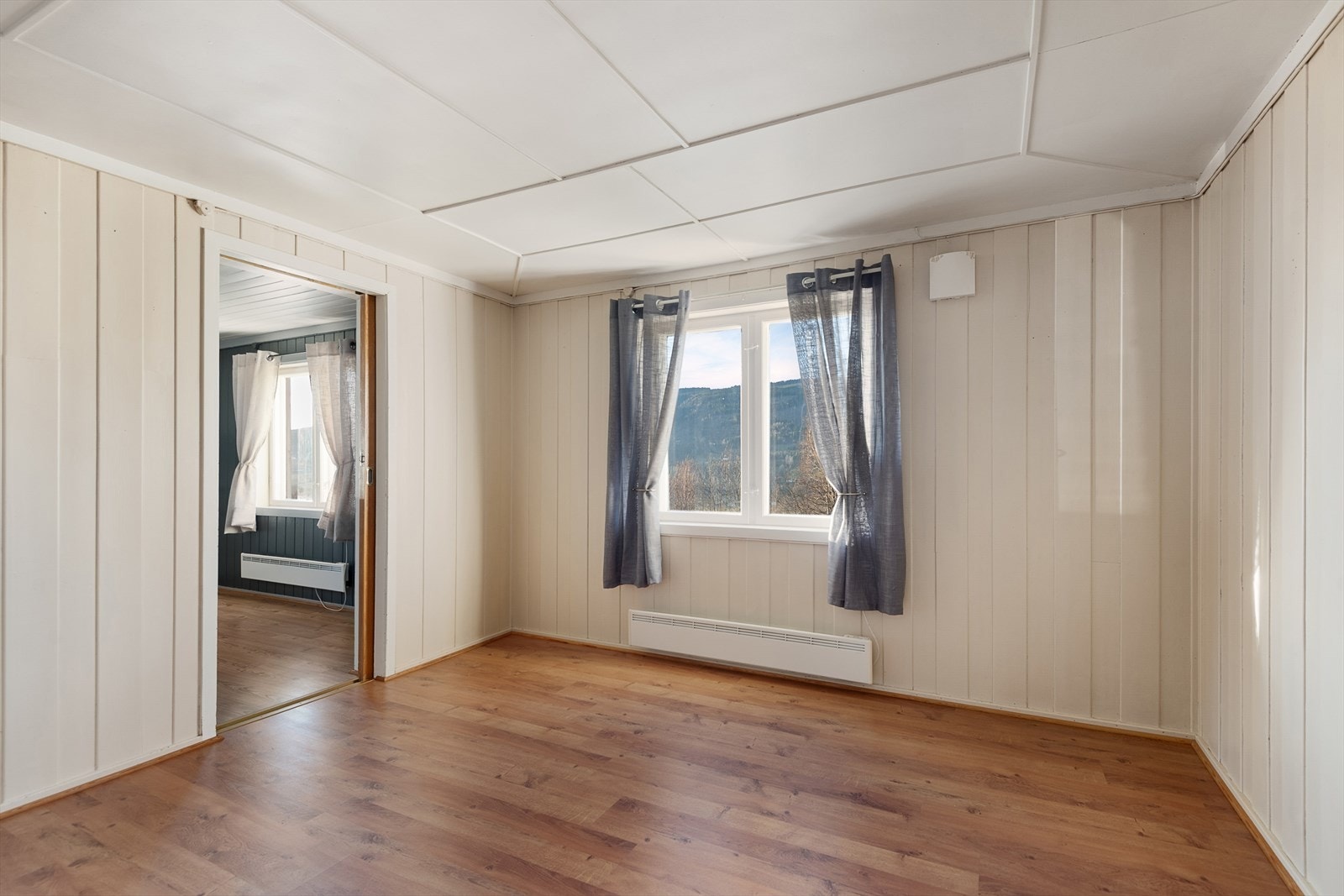 Det er skyvedør som er innfelt i vegg mellom stuen og kjøkkenet. Galleribilde