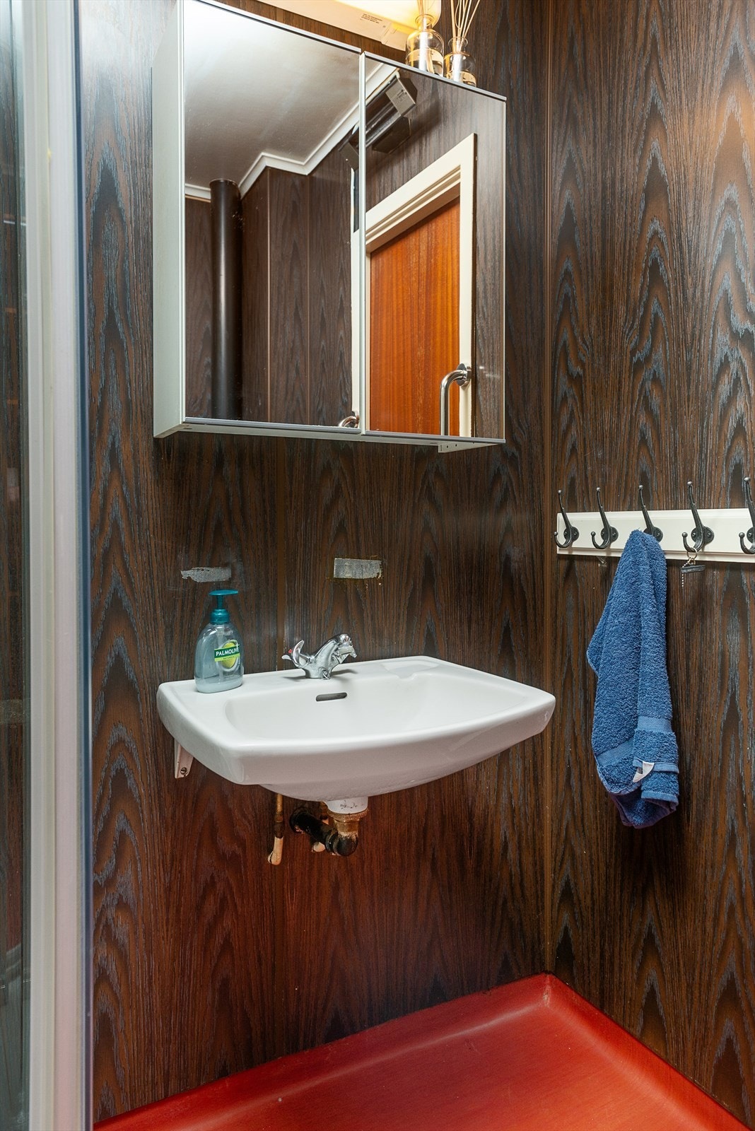 Servant med speilskap og lysarmatur på baderommet. Galleribilde