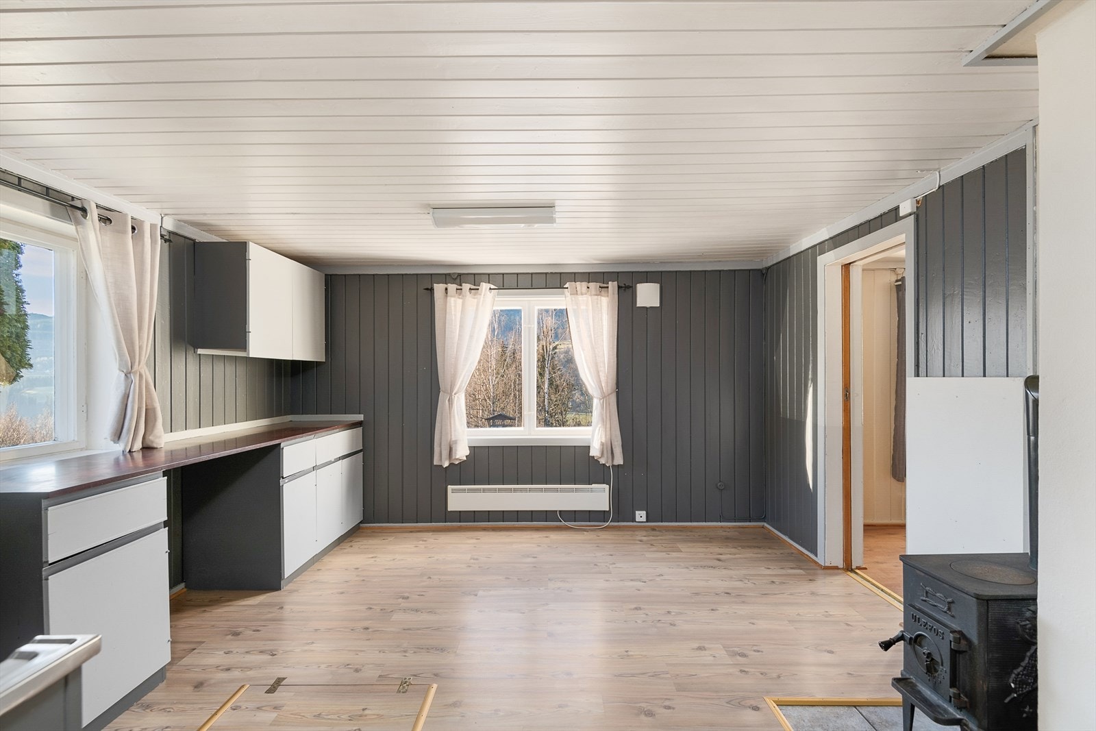 Godt med benkeplass og mye naturlig lys fra vindusflater på to vegger. Vedovnen sørger for god varme til rommet. Galleribilde