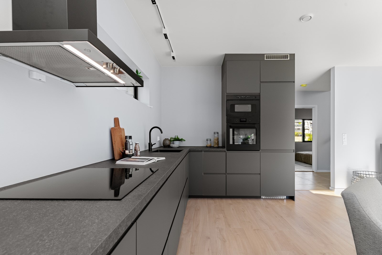 Nedfelt induksjonsplatetopp, høyskap med kjøl/frys og stekeovn + mikro. Underlimt kjøkkenvask i lekker, sort utførsele, med et tilhørende blandebatteri i samme stil. God belysning over benkeplassen. Galleribilde