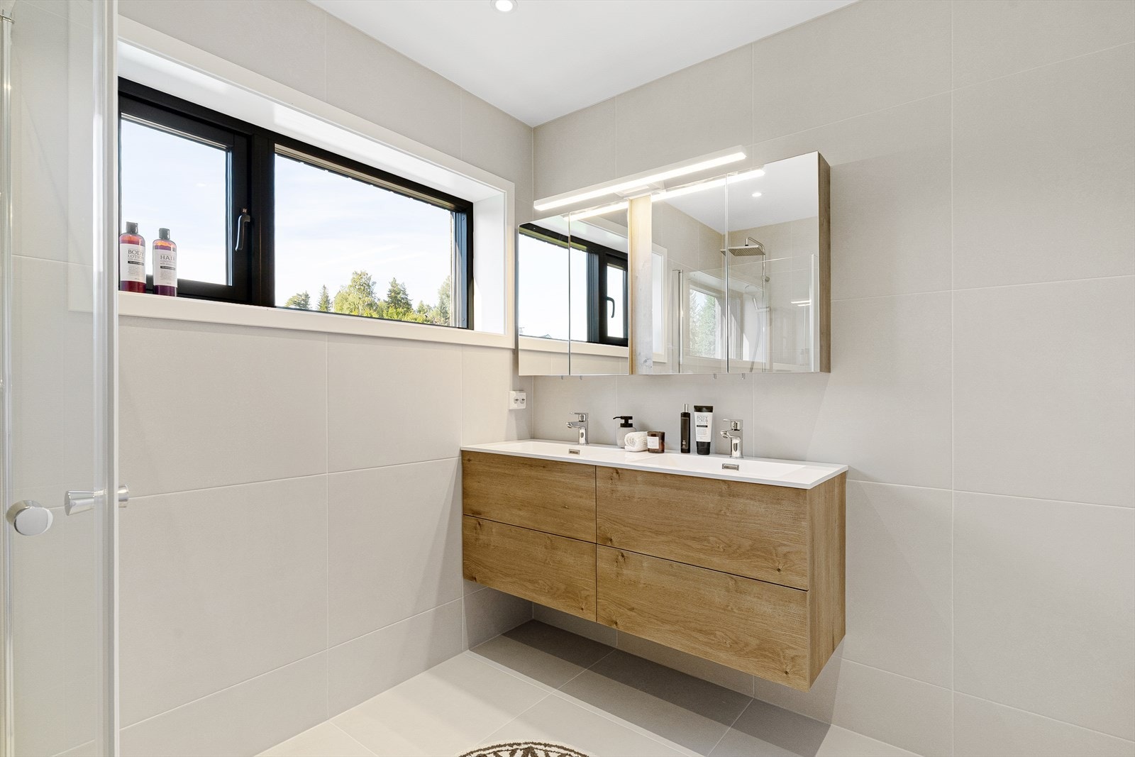 Badet oppe er i samme stilutførelse som nede. Her er også vegger flislagt. Dobbeltservant i lik stilutførelse som i første etasje. Helhetlig og gjennomført. Galleribilde