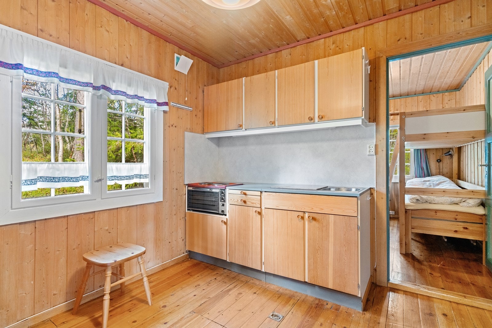 Kjøkkenet har glatte fronter og laminat benkeplate, samt plass til kjøleskap og hybelkomfyr. Galleribilde