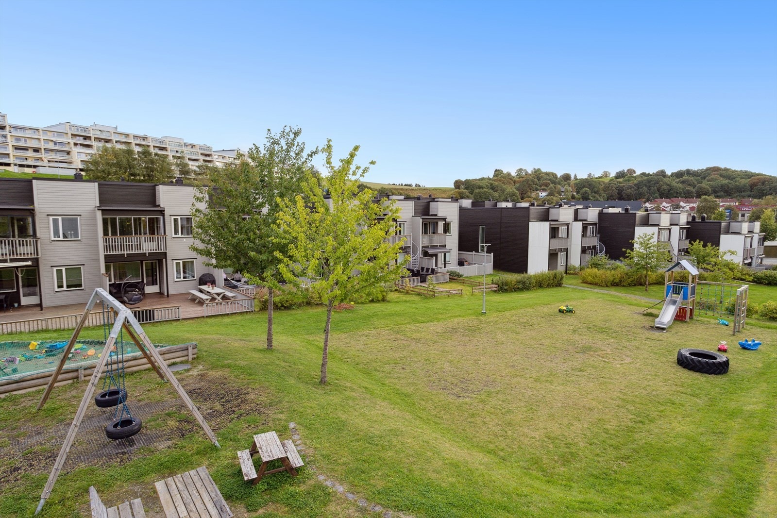 Fra balkongen kan man se den velholdte lekeplassen som er omkranset av rekkehus. Galleribilde