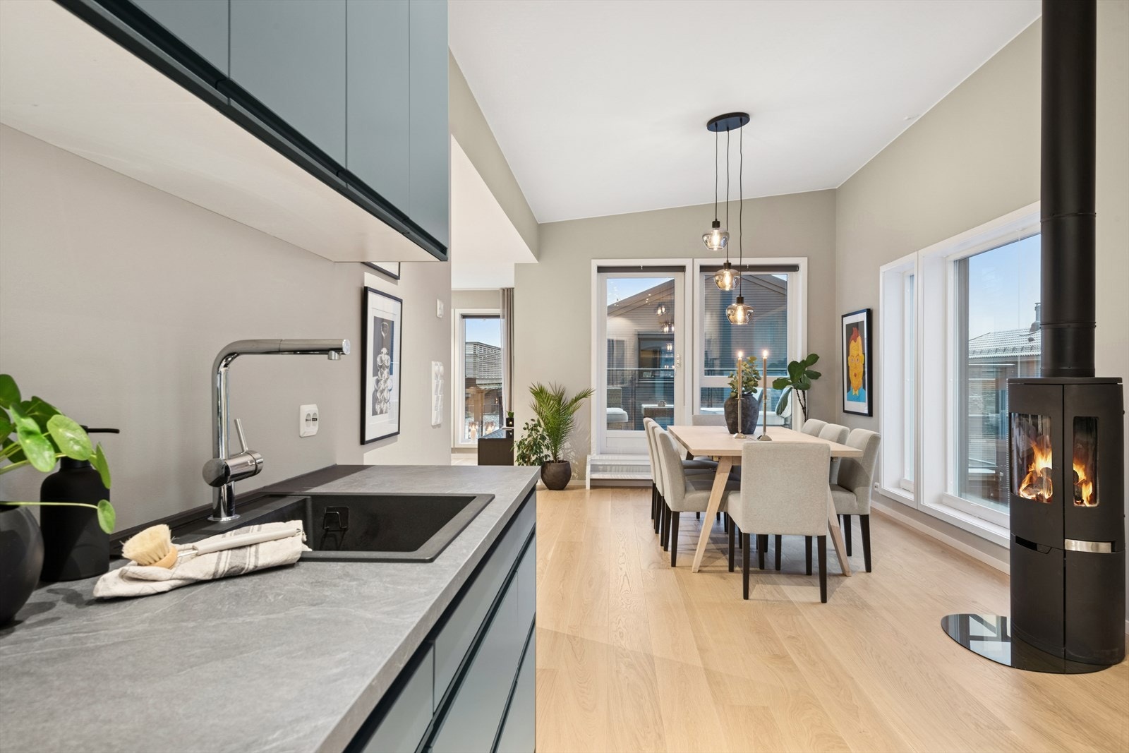 Fra kjøkkenet er det utsyn mot spiseplass og stue med peisovn. Galleribilde