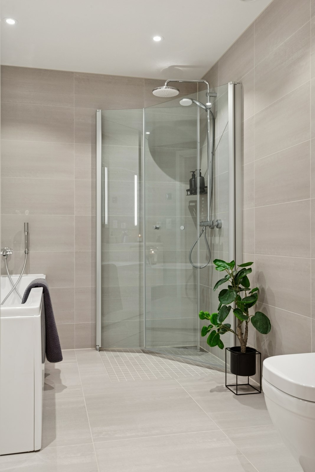 Dusjhjørne med innfellbare dører i herdet glass og dusjsett med både hånd- og regndusj. Galleribilde