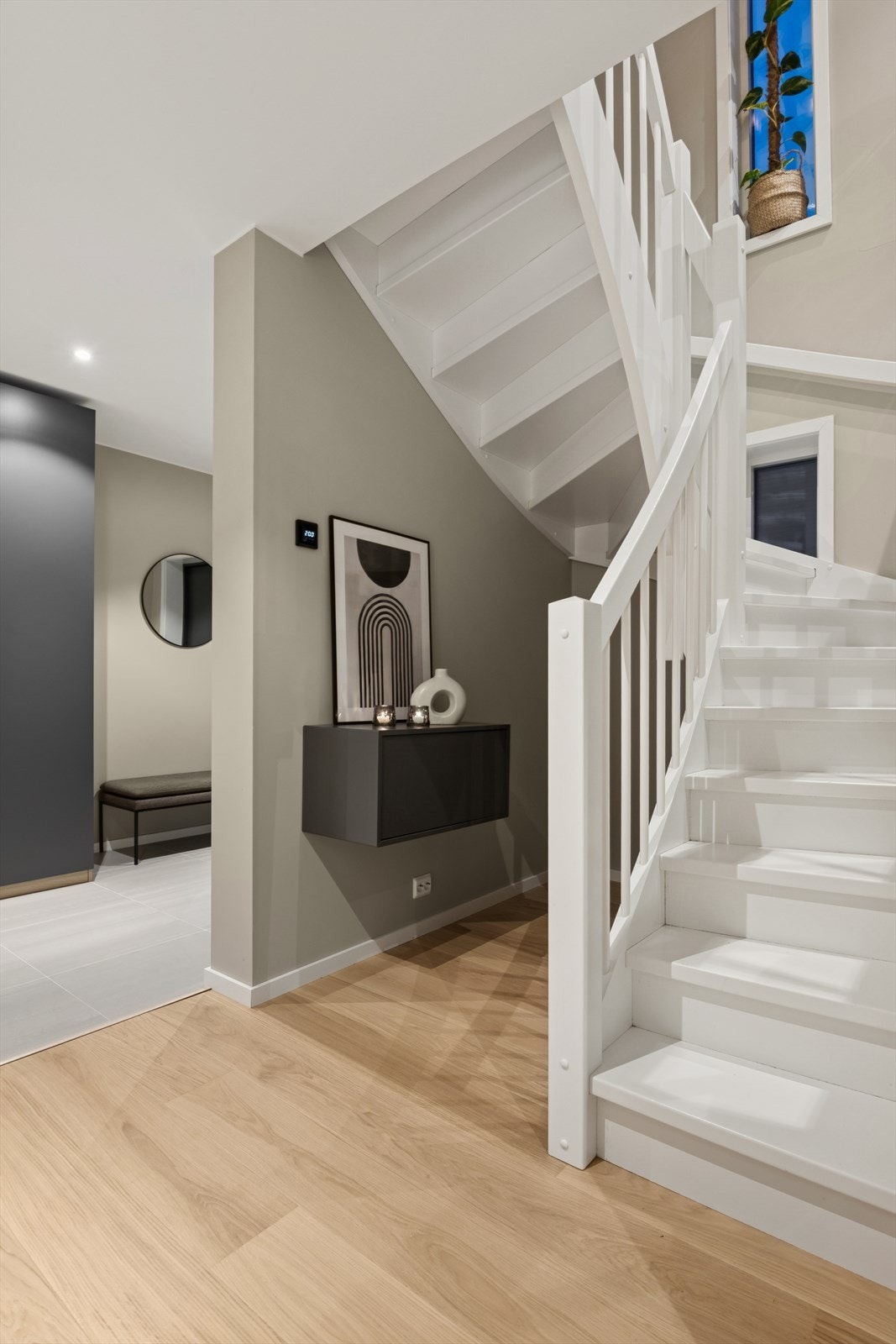 Hvitmalt tretrapp gir en elegant overgang mellom etasjene. Galleribilde