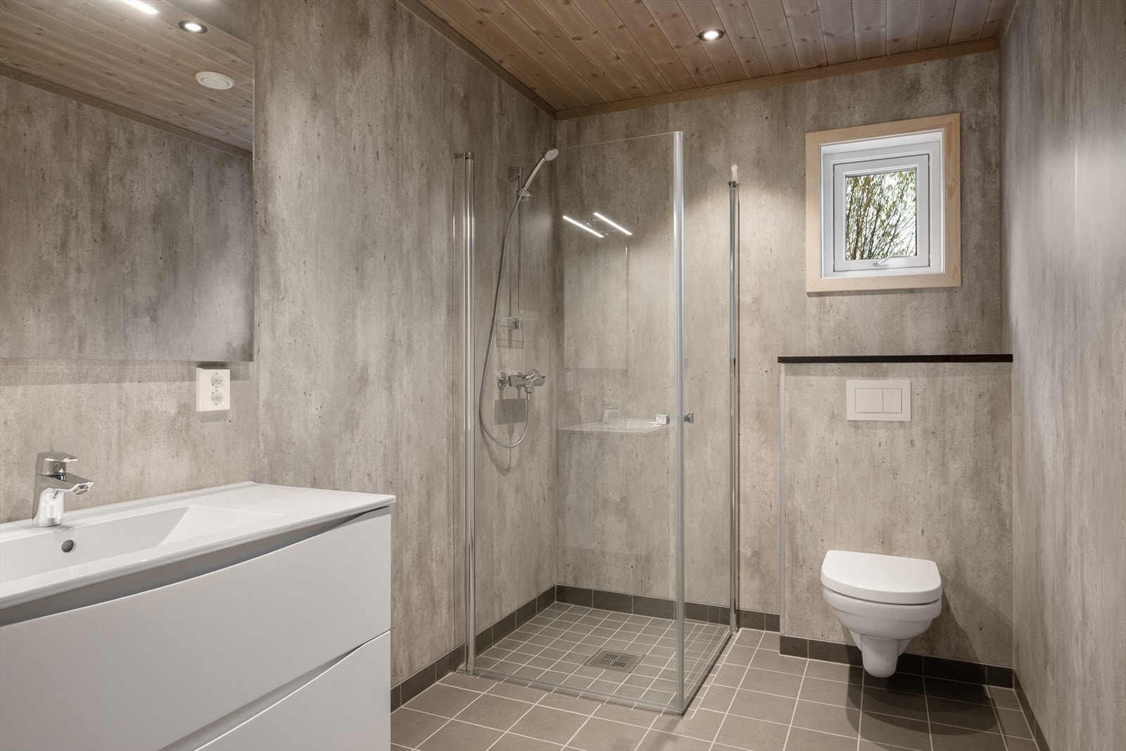 Badet har plater på vegg og flislagt gulv, og lyst interiør. Galleribilde